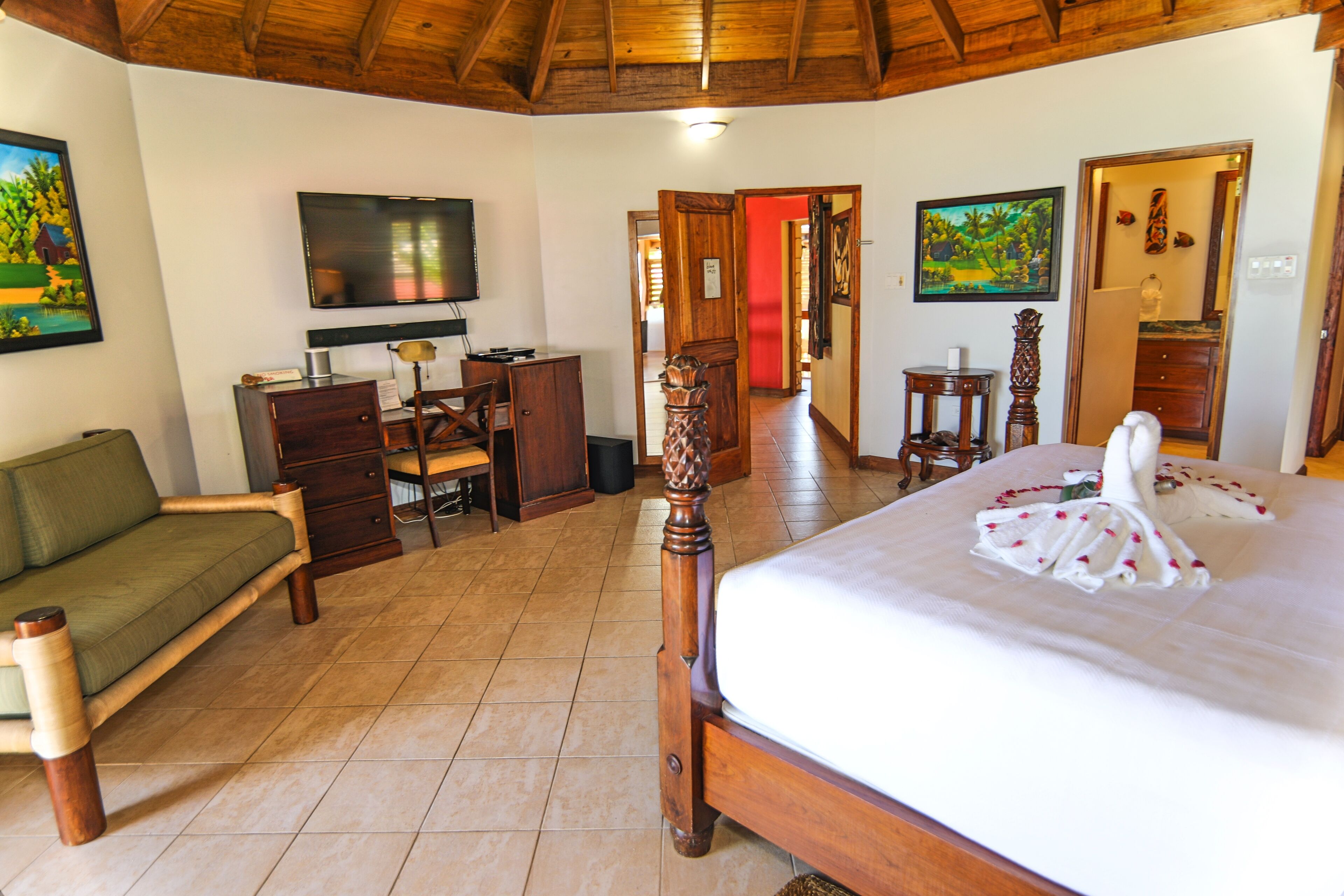 A bedroom with a four-poster bed and a sofa.