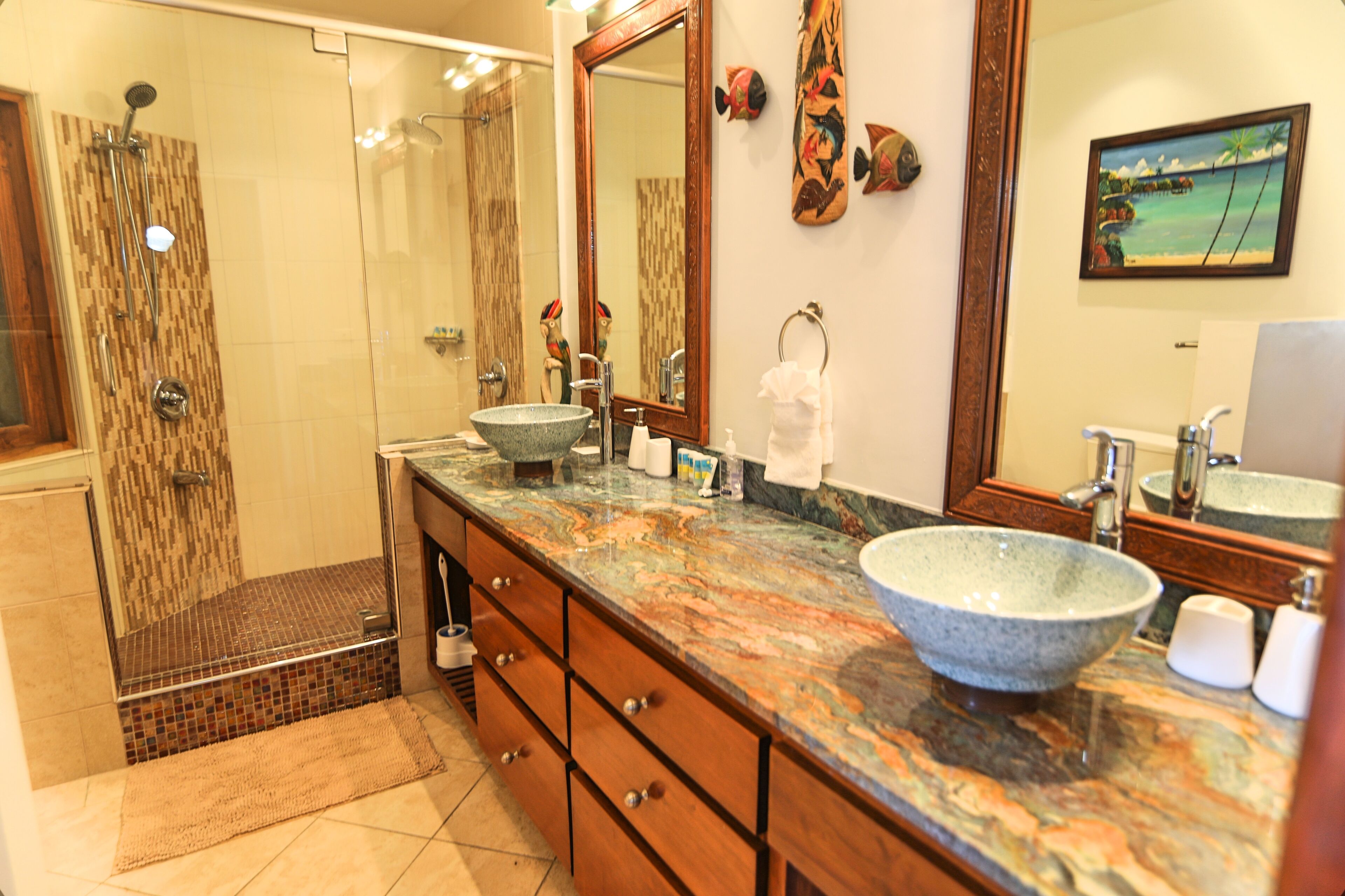 A bathroom with two sinks and a shower.