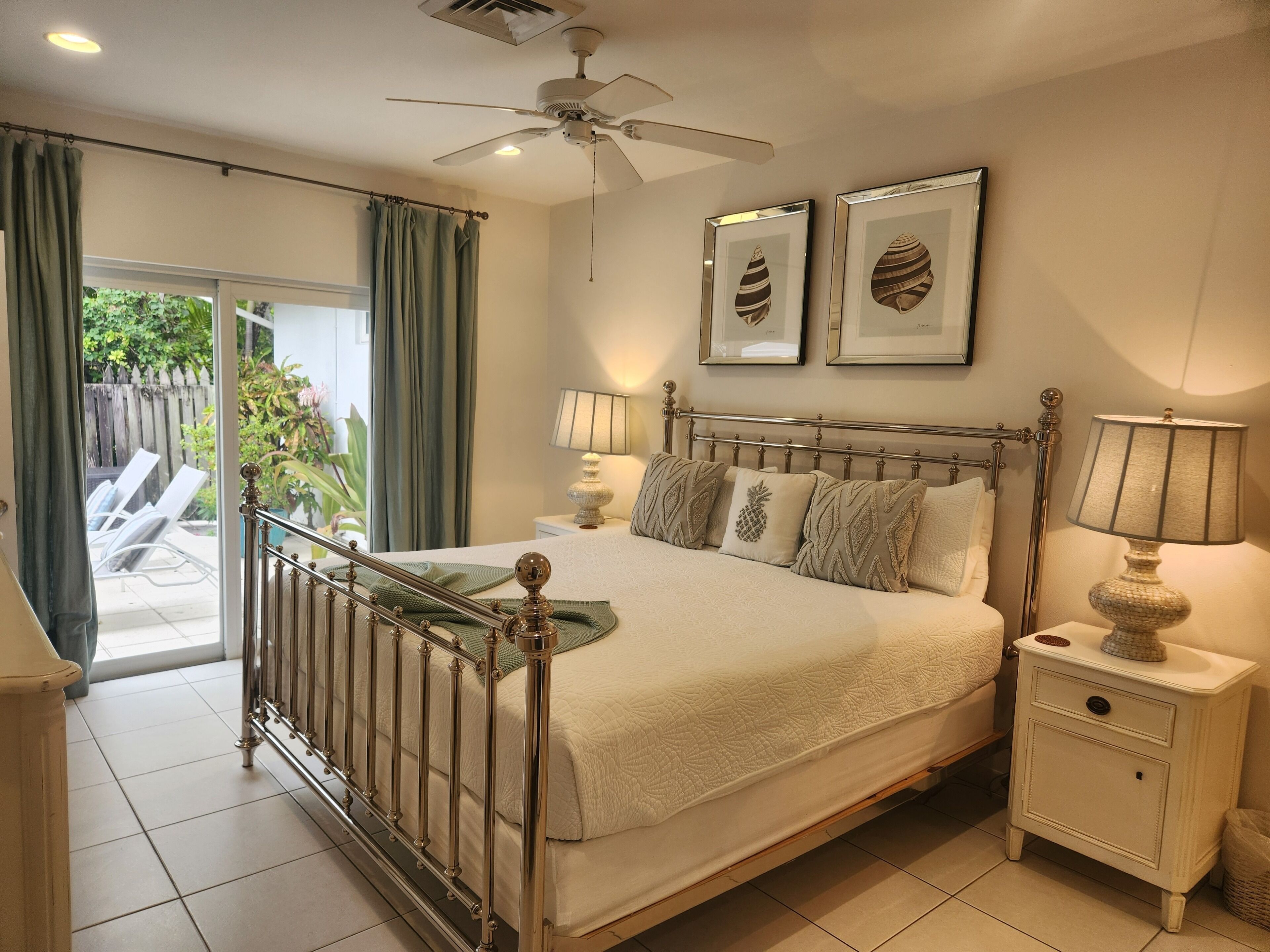 A bedroom with a metal bed frame and a door to the patio.