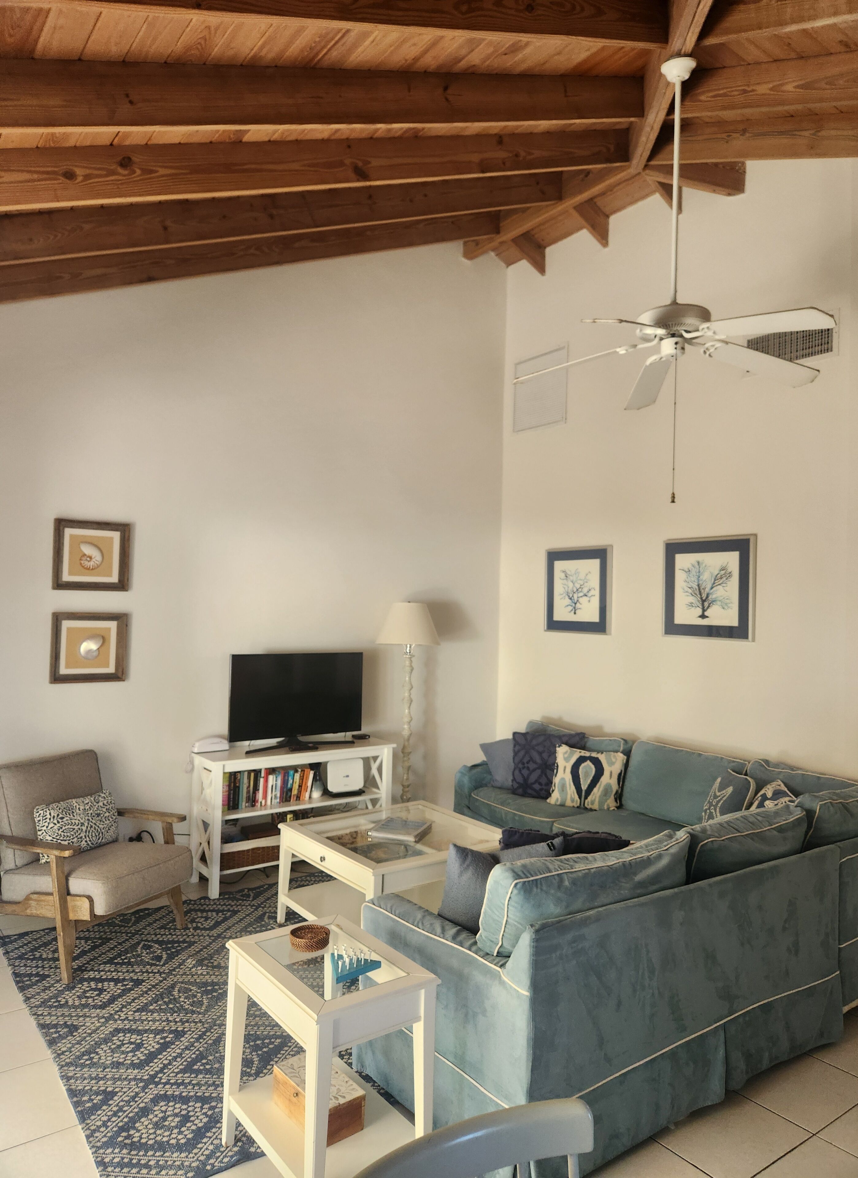 A living room with a television and a blue corner sofa.