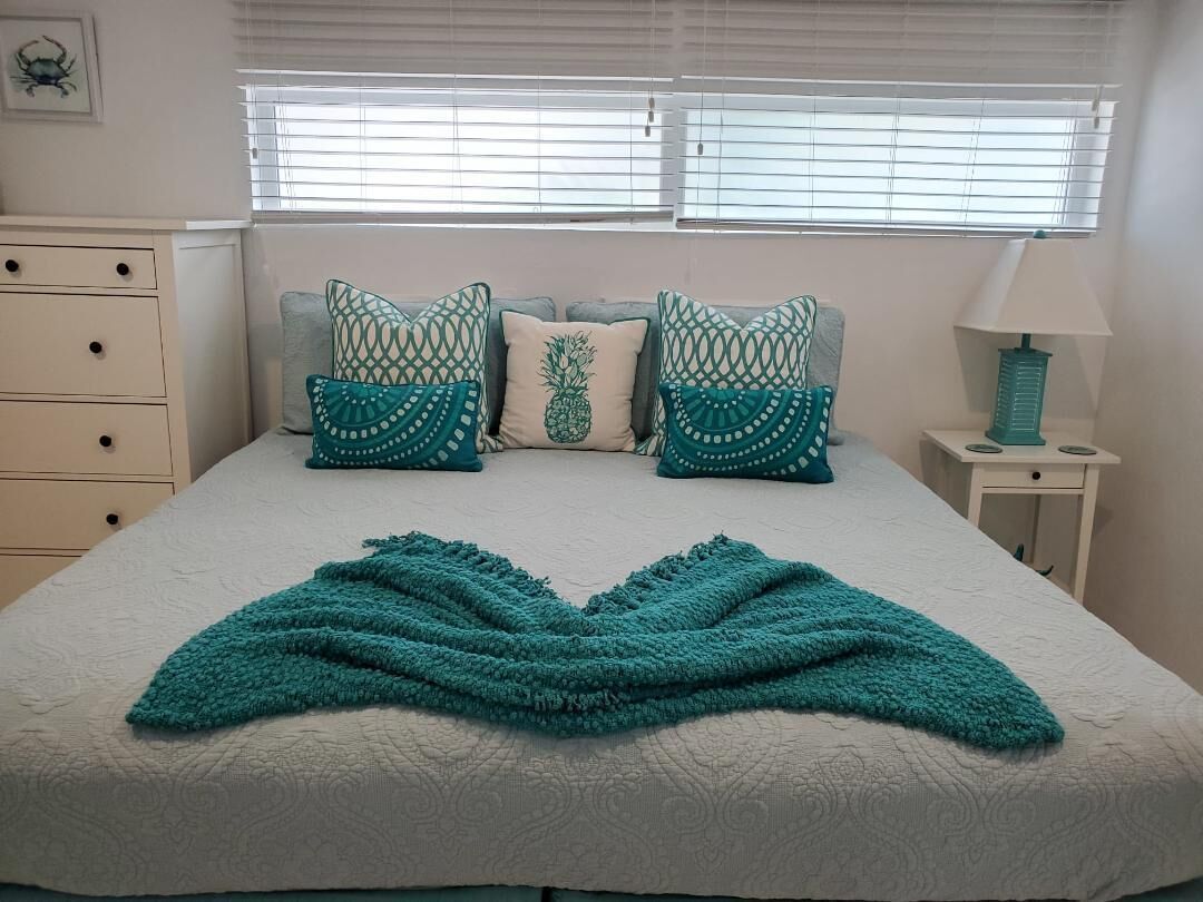 A bed with teal pillows and a teal blanket.
