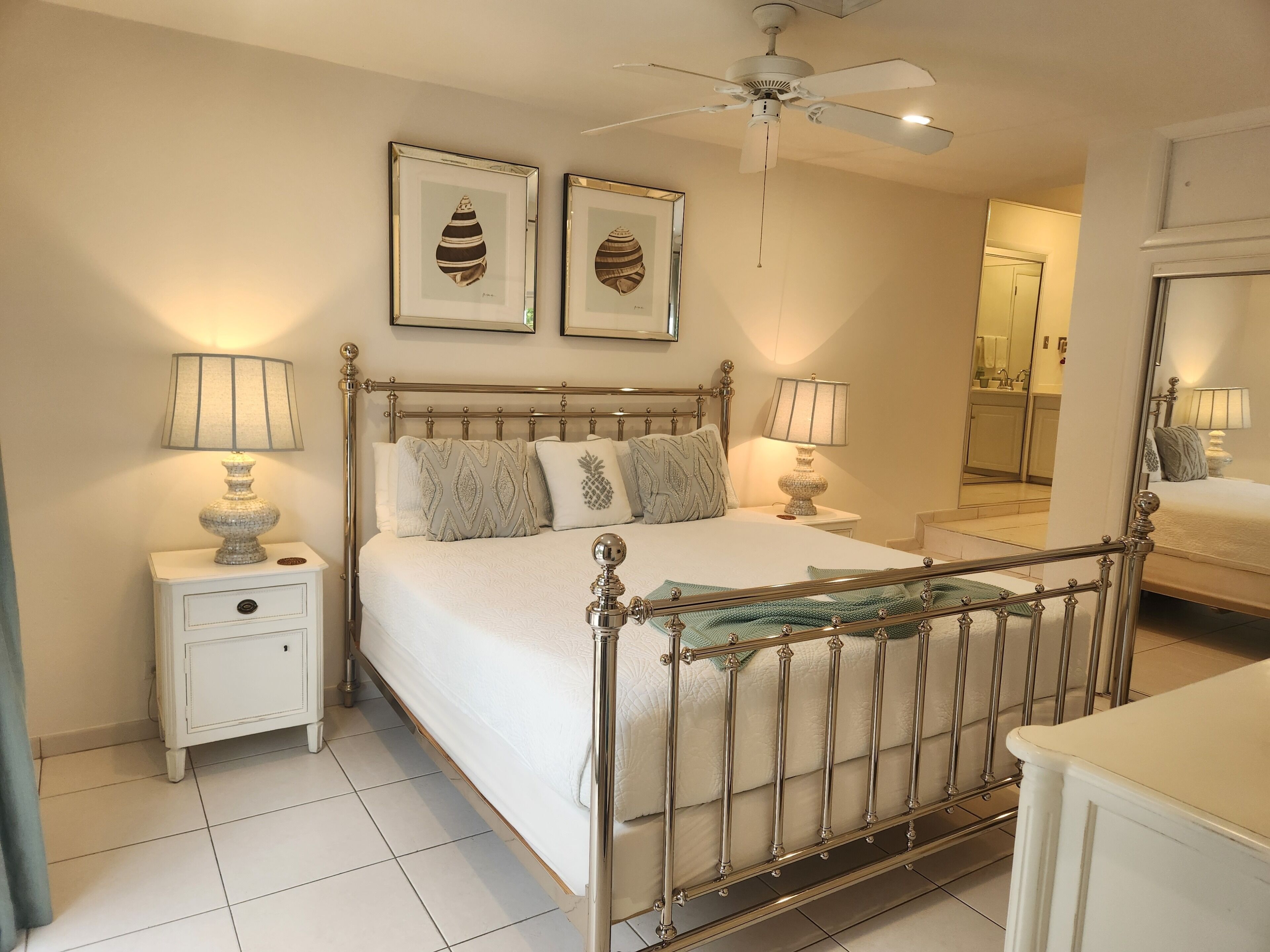 A bedroom with a metal bed frame and two table lamps.