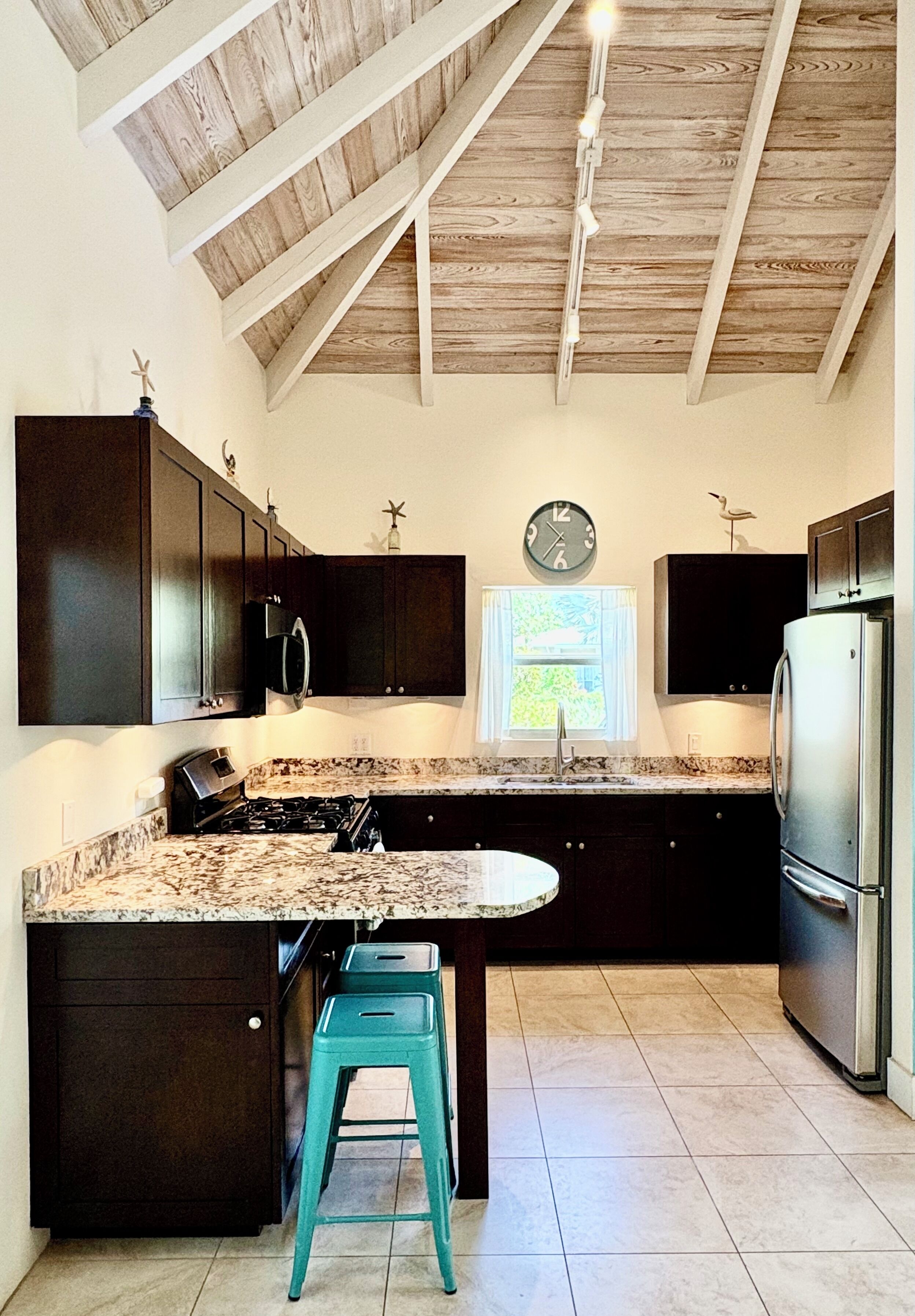 The kitchen has granite counters, a gas stove, and a refrigerator.
