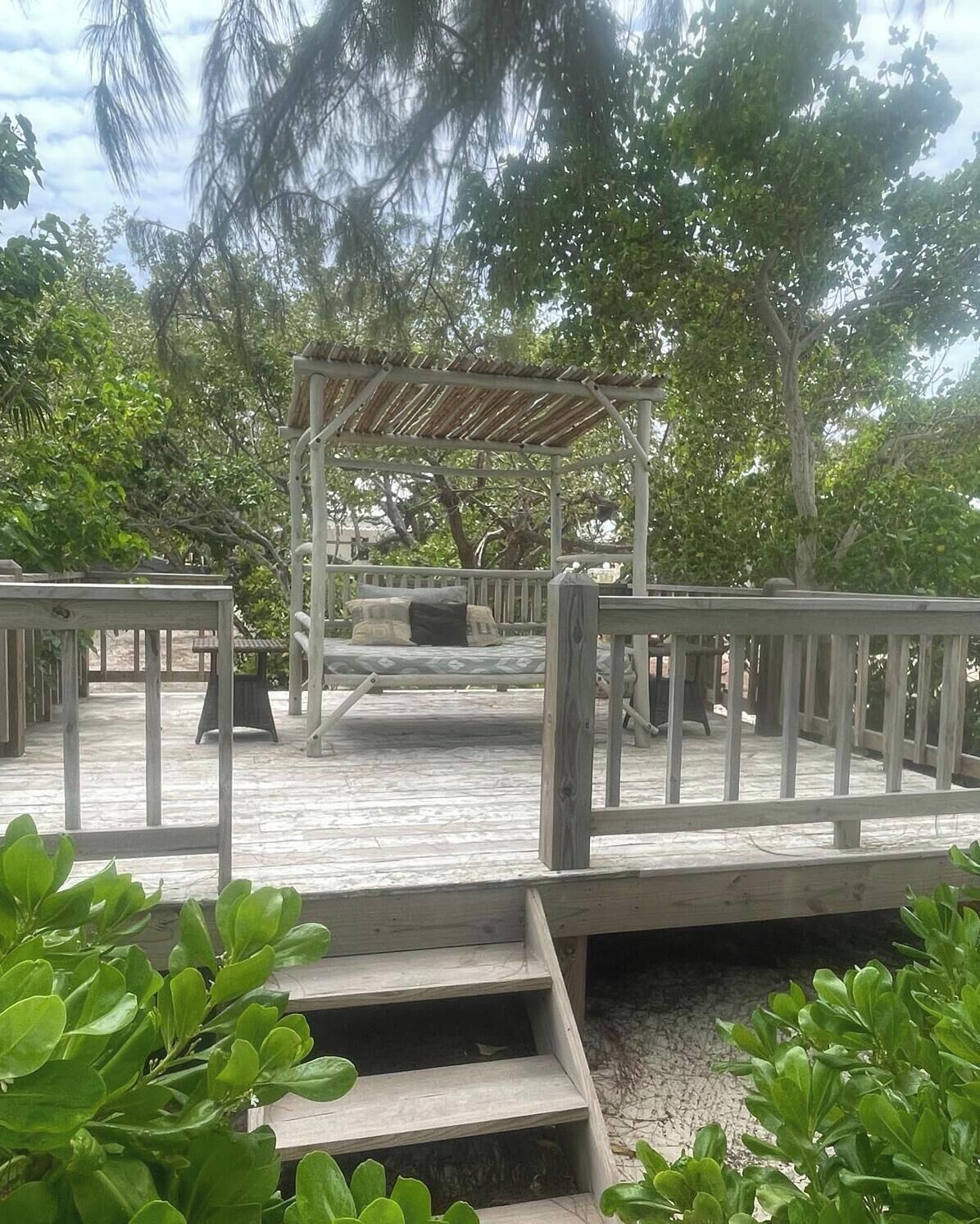 A pergola with a daybed on the deck.