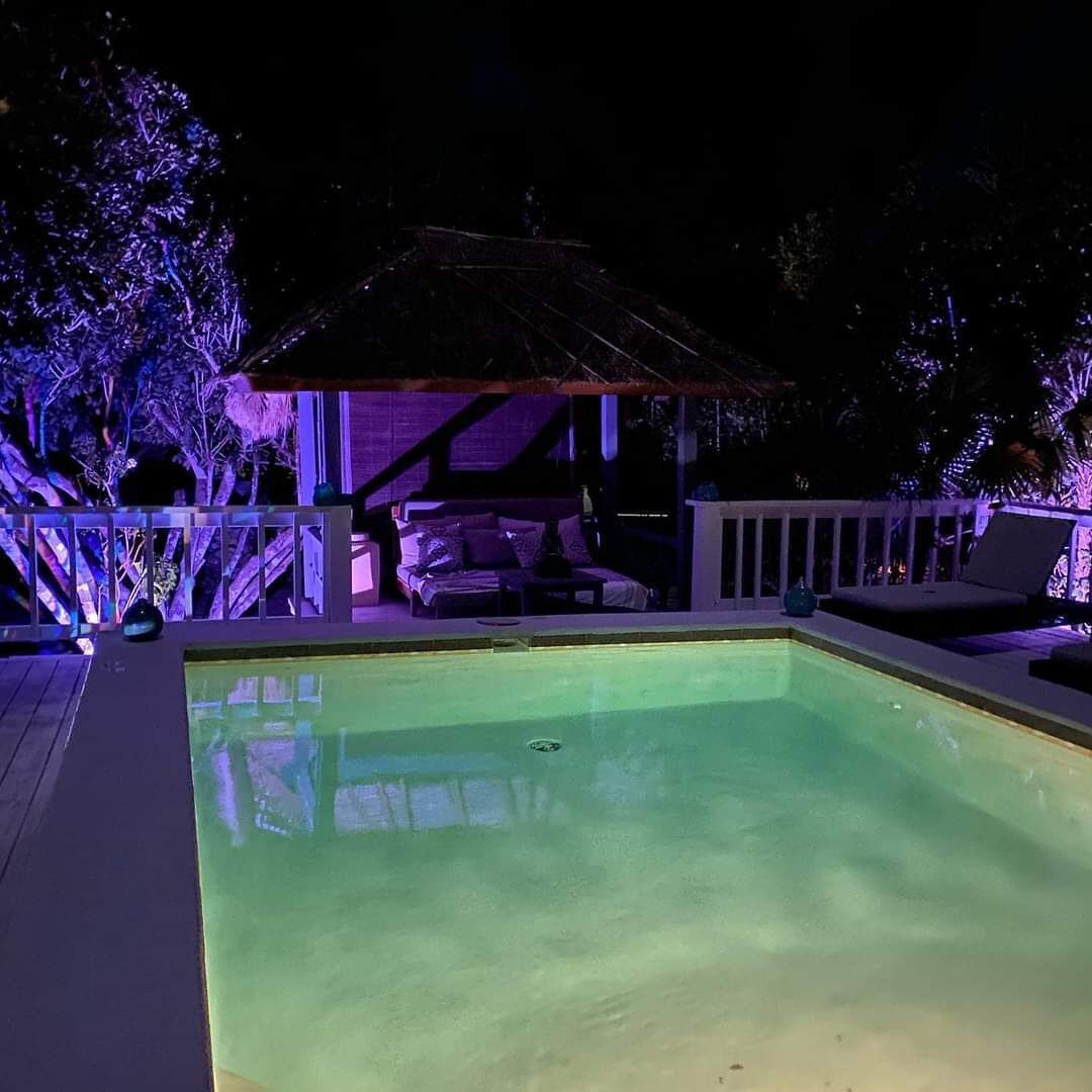 The pool and the thatch hut at night.
