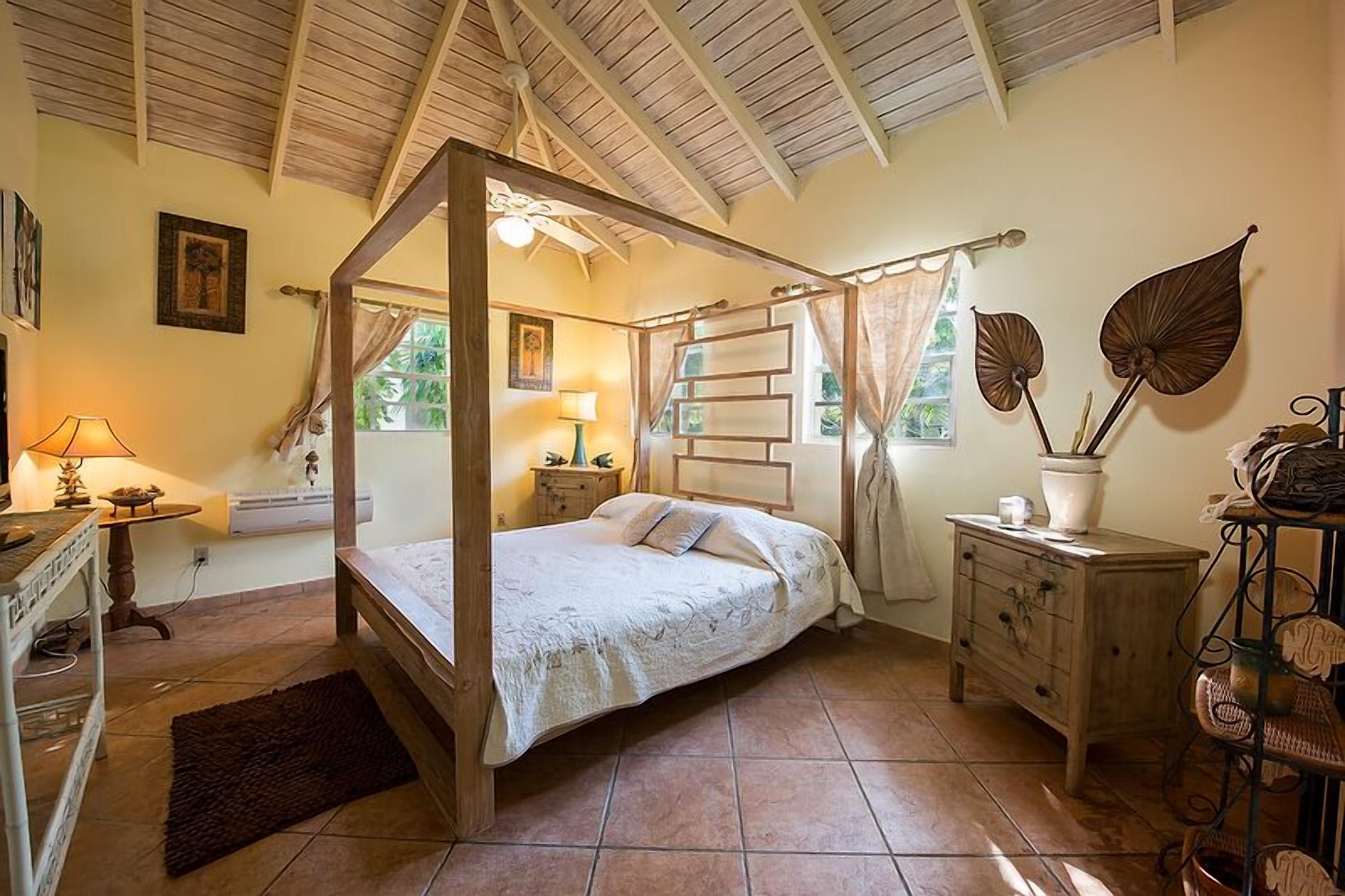A bedroom with a wood four-poster bed.