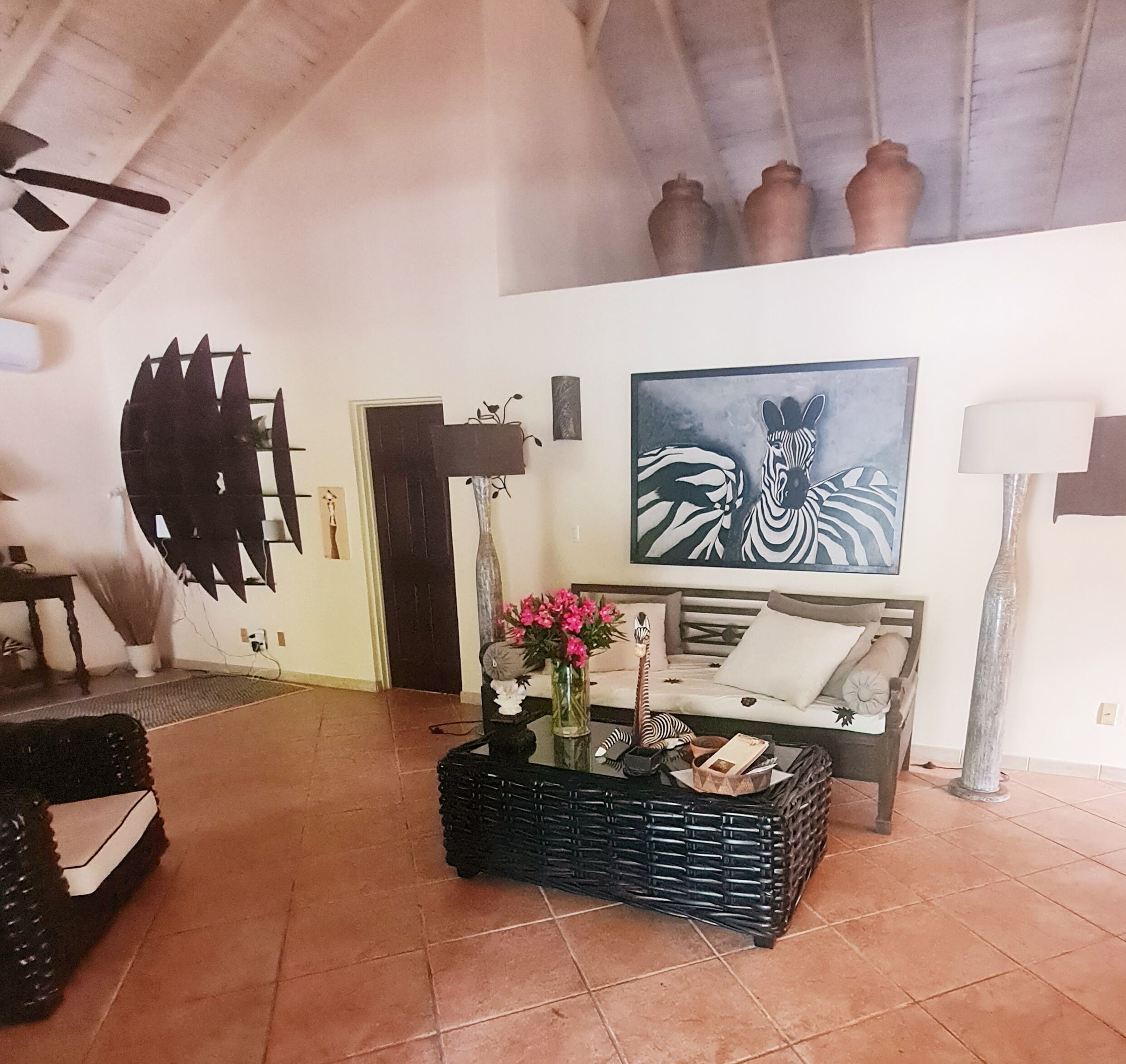 The living room with a daybed and a zebra painting.