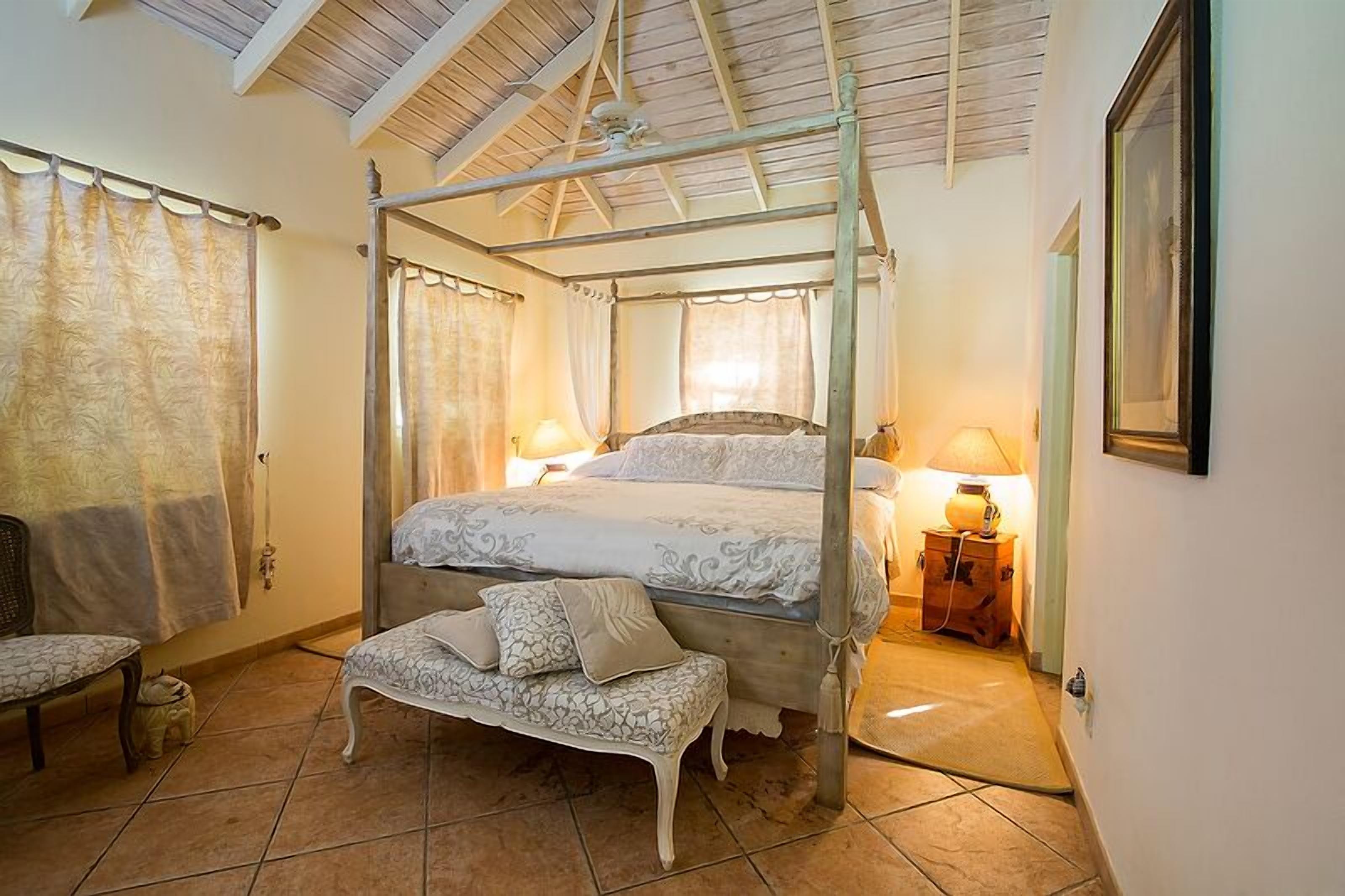 A four-poster bed with white bedding.