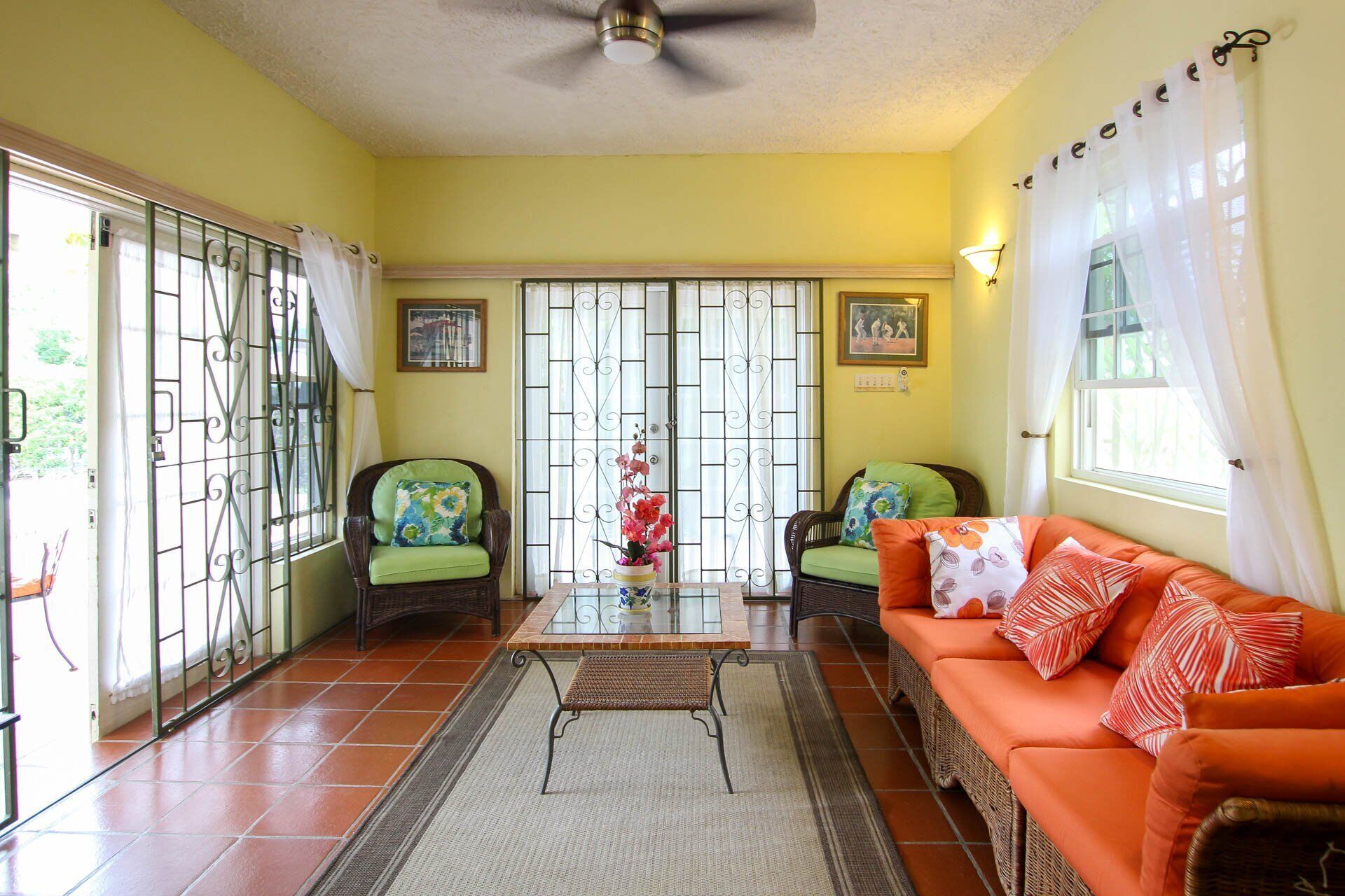 The sitting room with wicker seats and patio doors.
