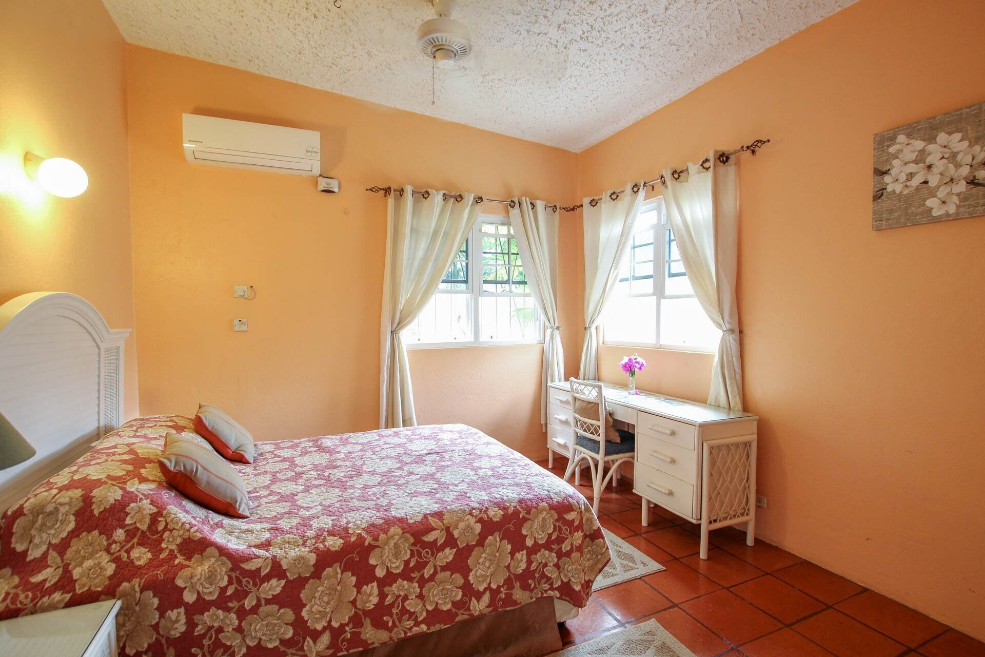 A bedroom with a double bed and a desk.