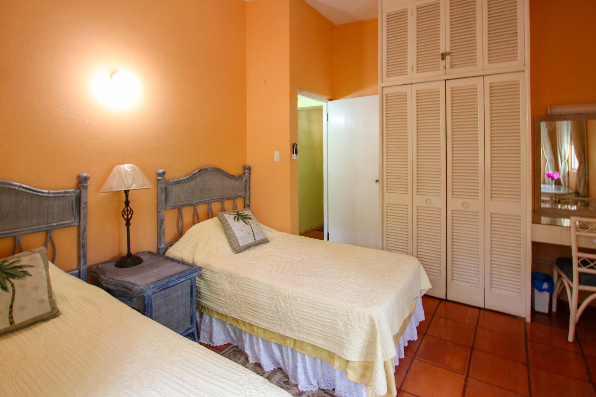 A bedroom with two single beds and a closet.