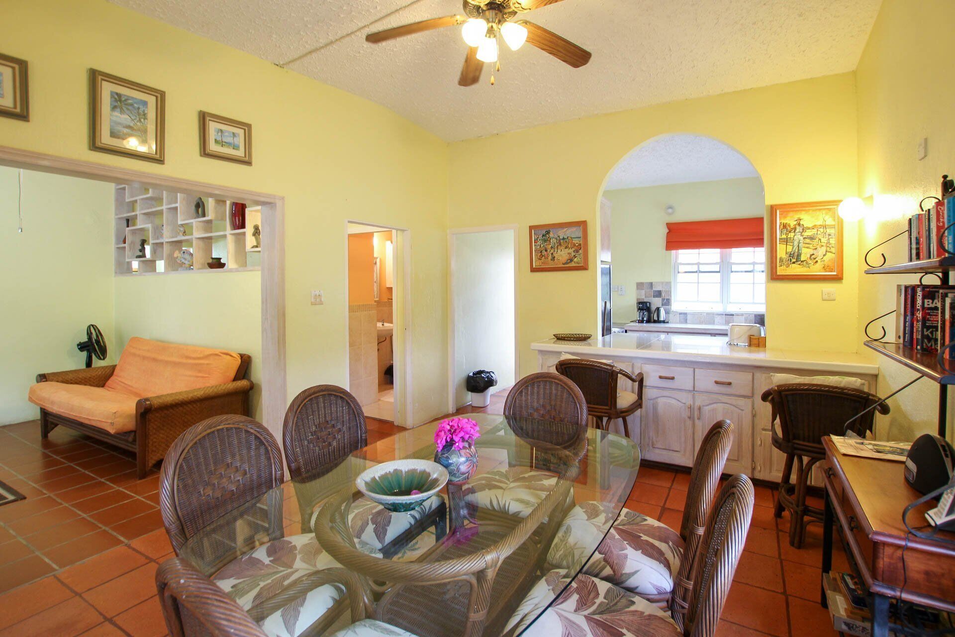 The dining area with a glass table, next to the kitchen.
