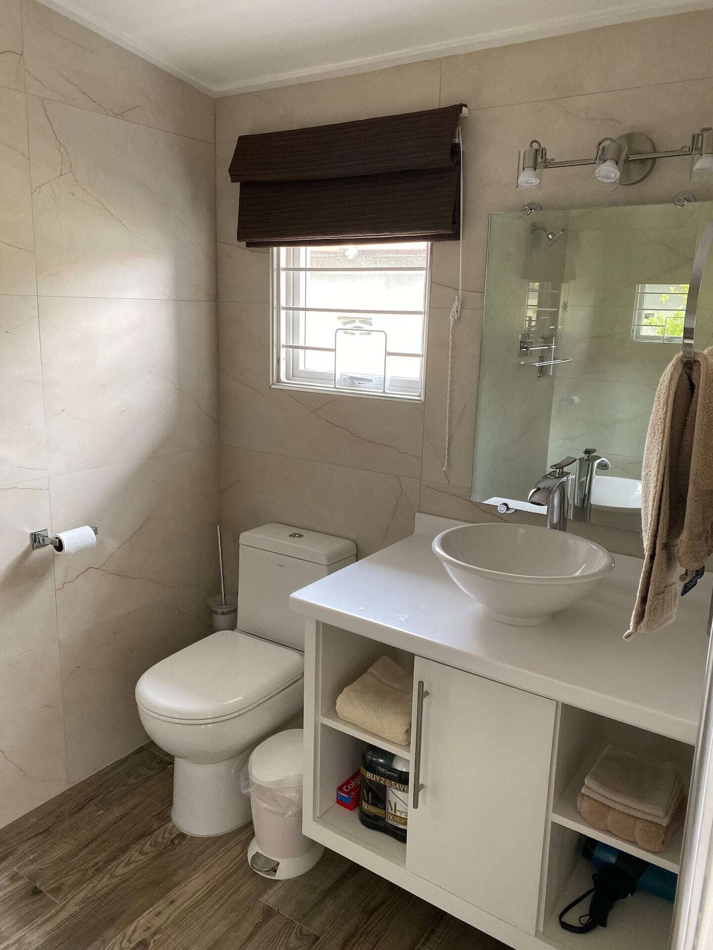 A bathroom with a toilet, a bowl sink, and a mirror.