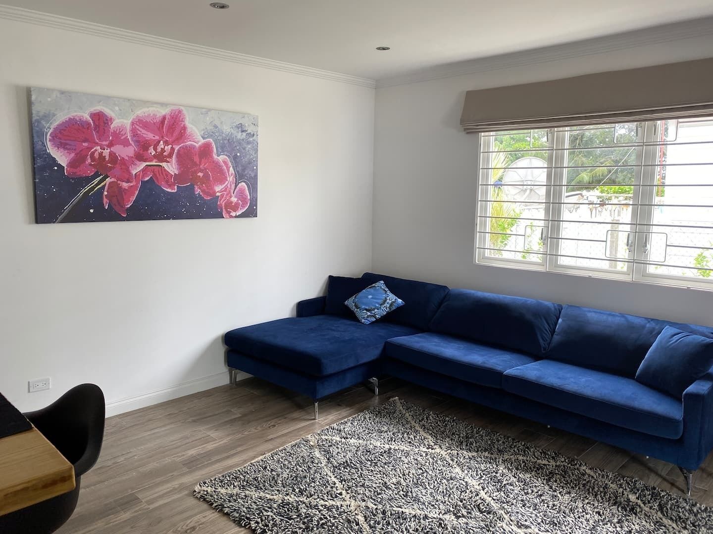 A living room with a blue corner sofa and a rug.