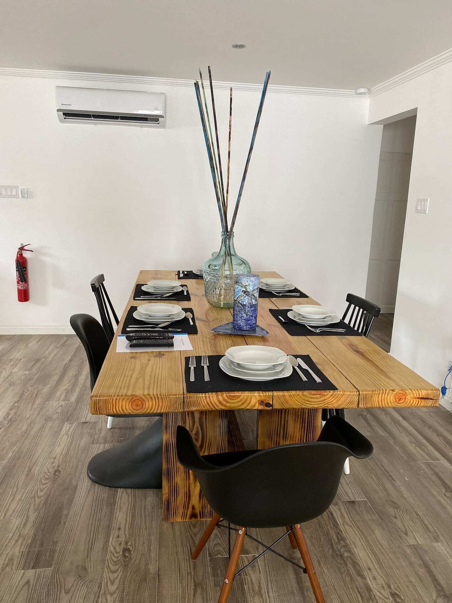 A wood dining table with six place settings.