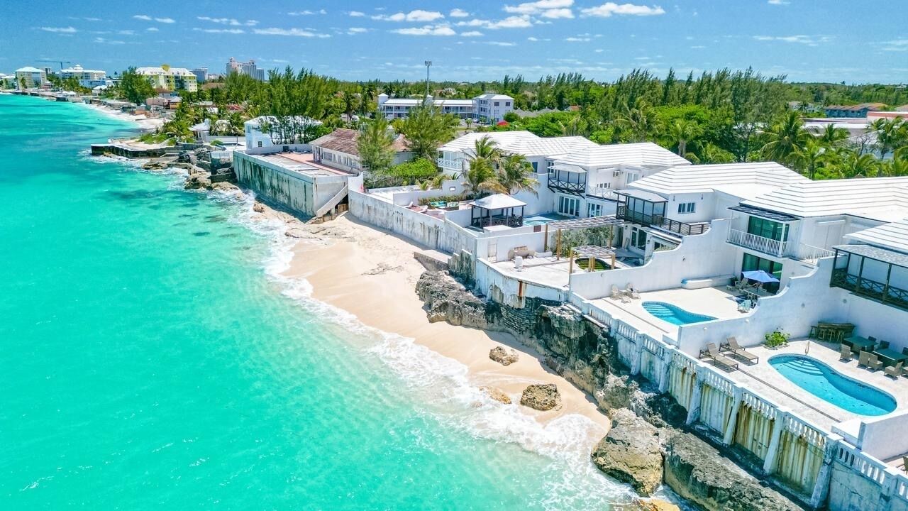 An aerial view of the oceanfront villas, the pools, and the beach.