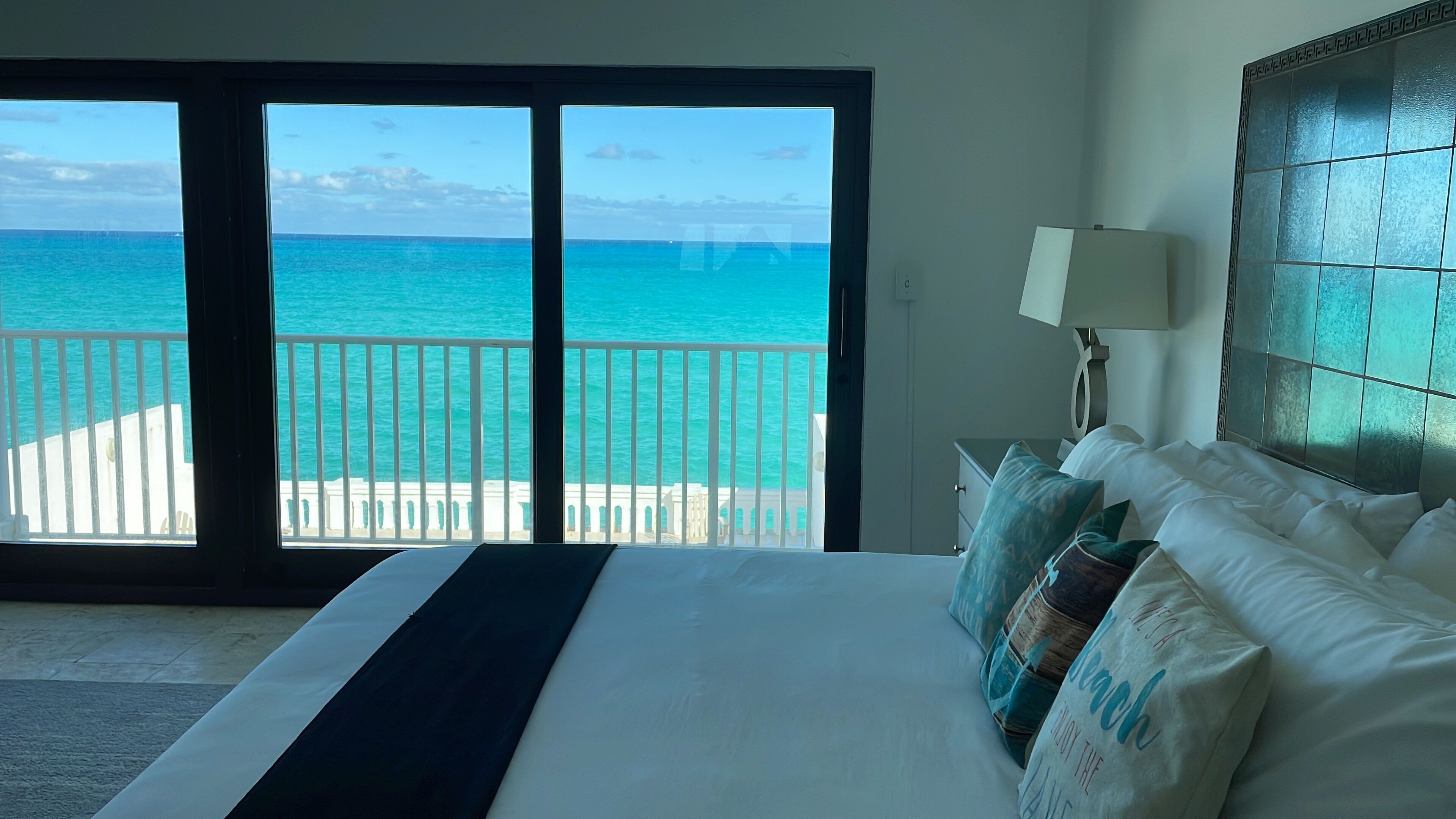 A bedroom with a wide view of the sea through the sliding doors.