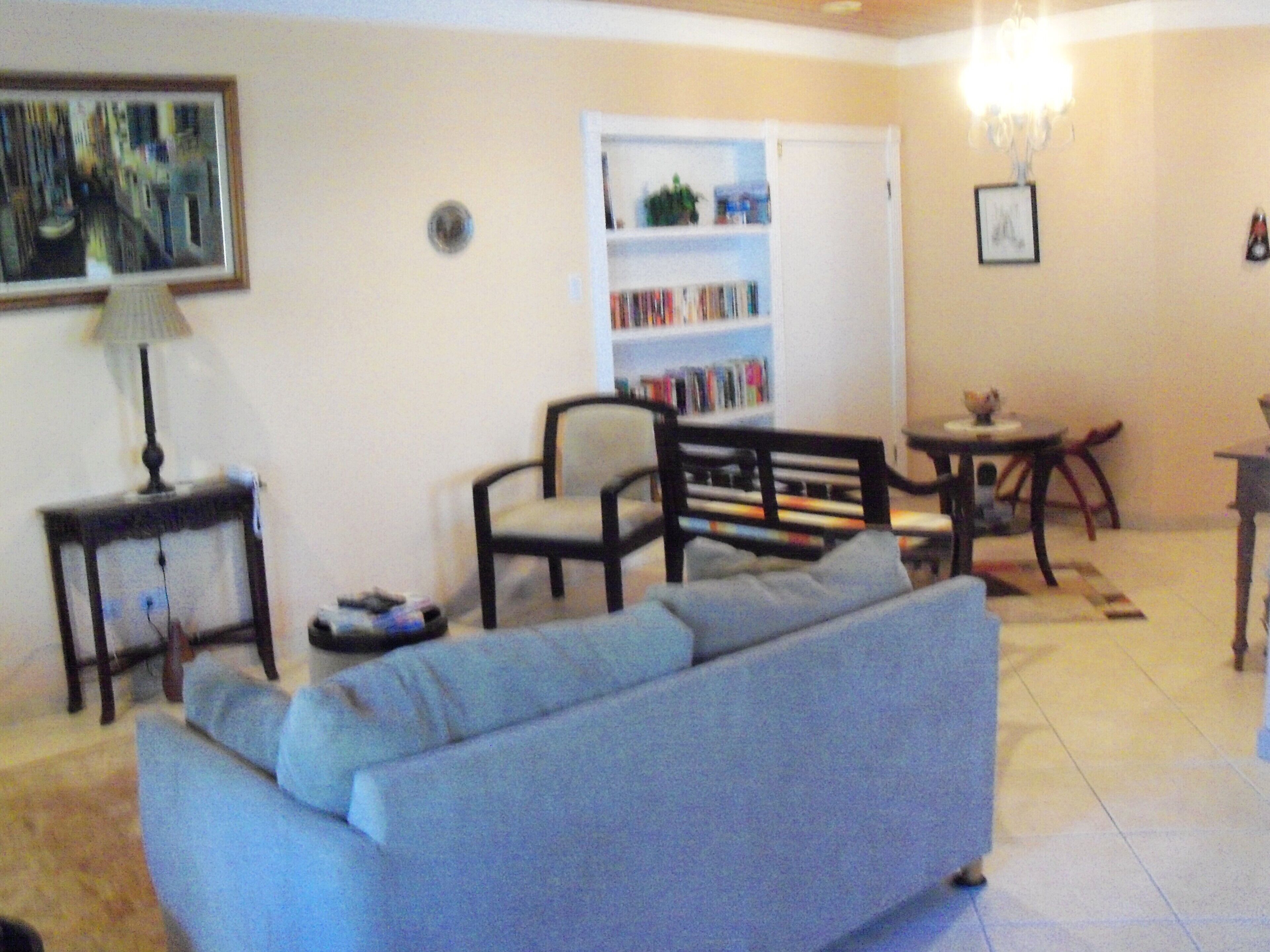 The living room has a sofa, chairs, and a bookshelf.