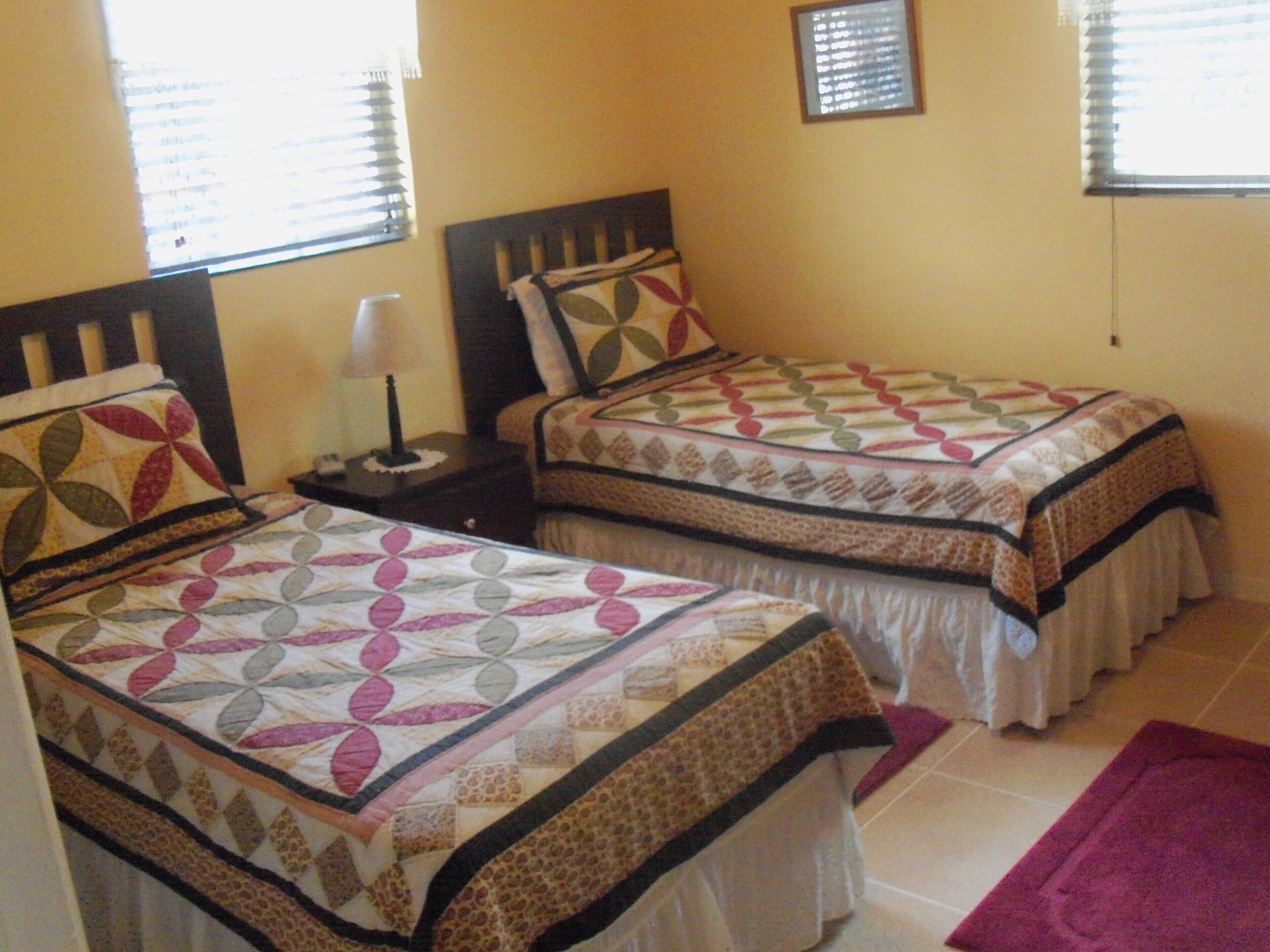 The bedroom has two twin beds and a nightstand with a lamp.