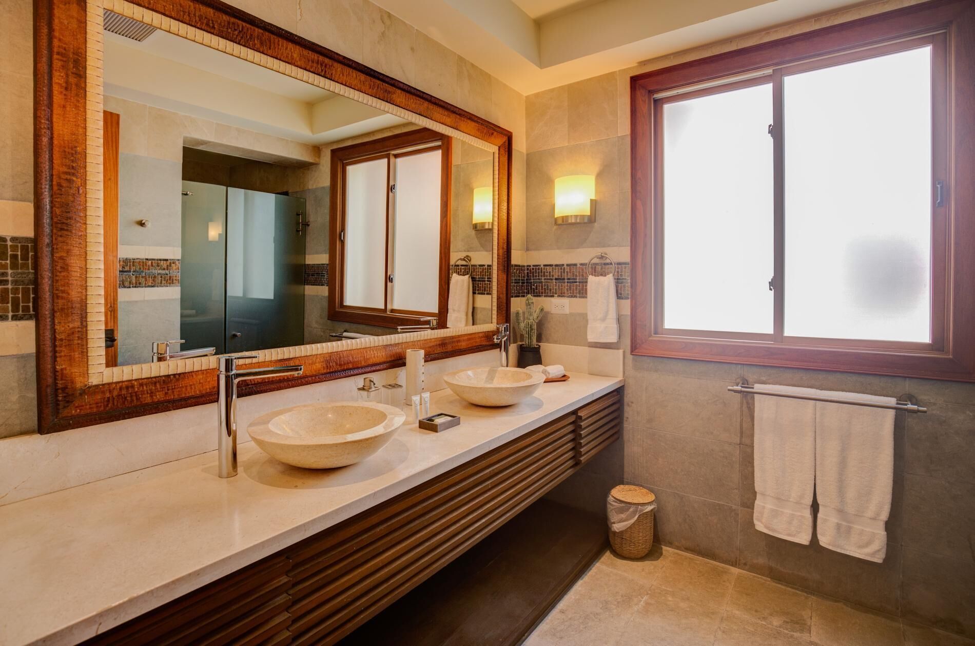 A bathroom with two stone sinks and a large mirror.