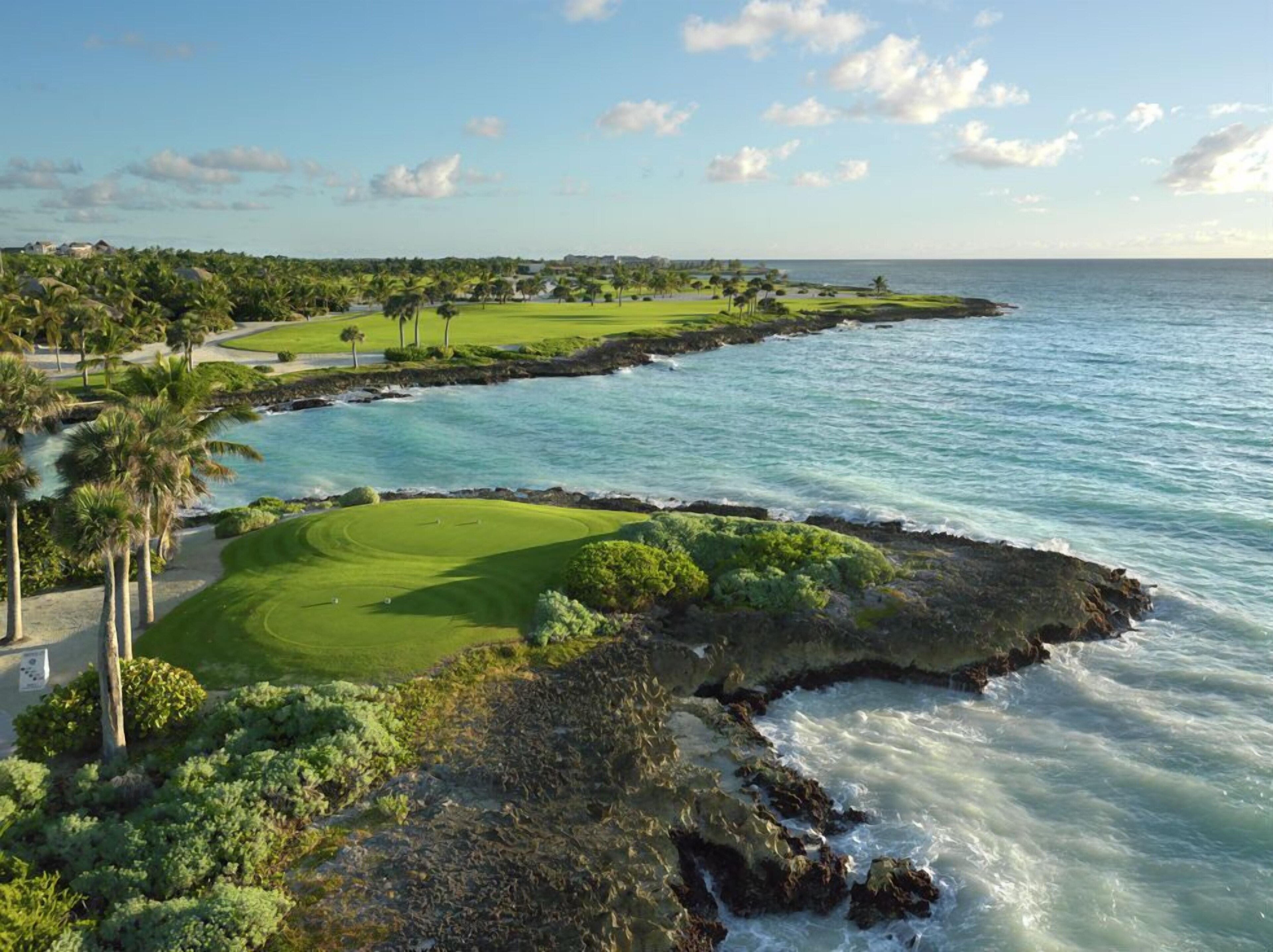 An aerial view of a golf course on the sea coast.