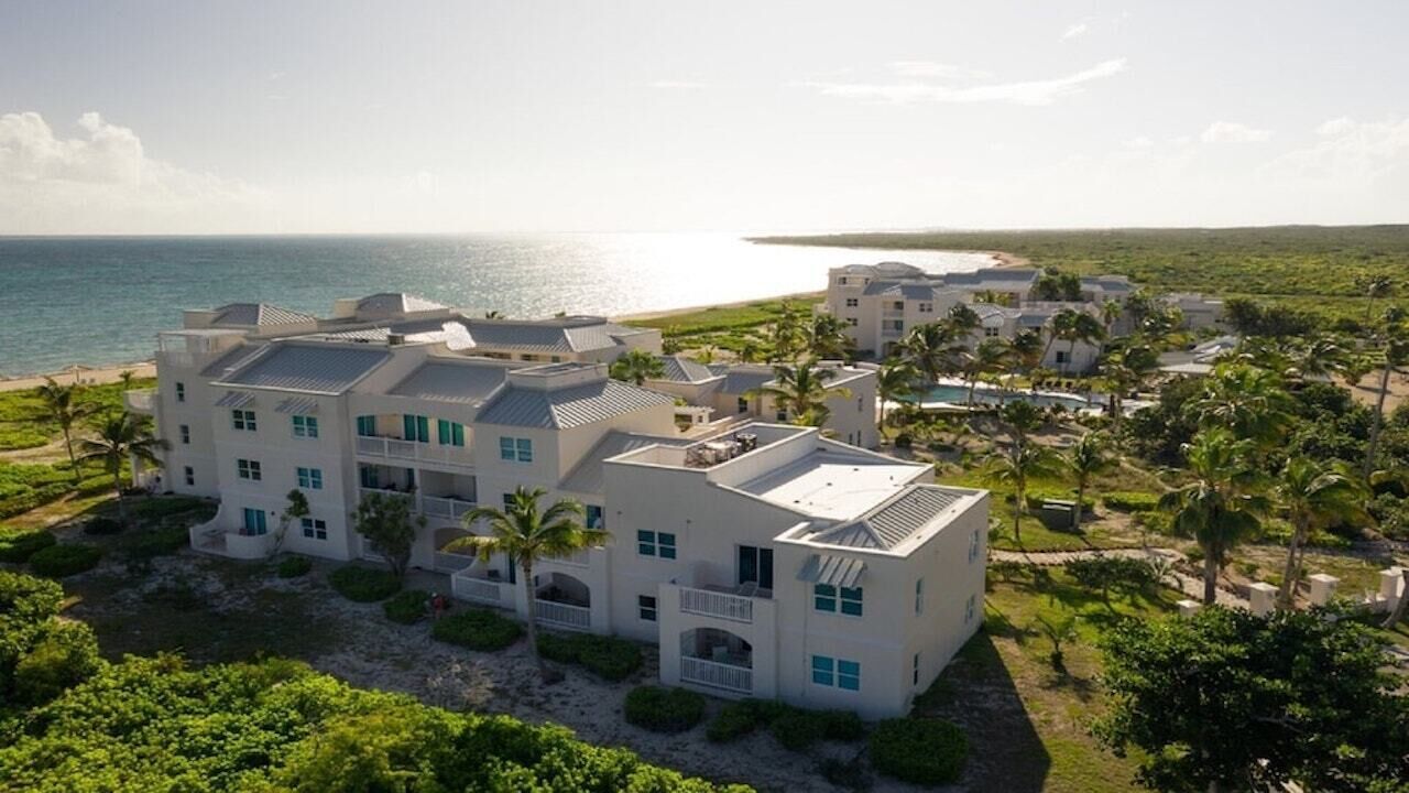An aerial view of the white buildings next to the sea.