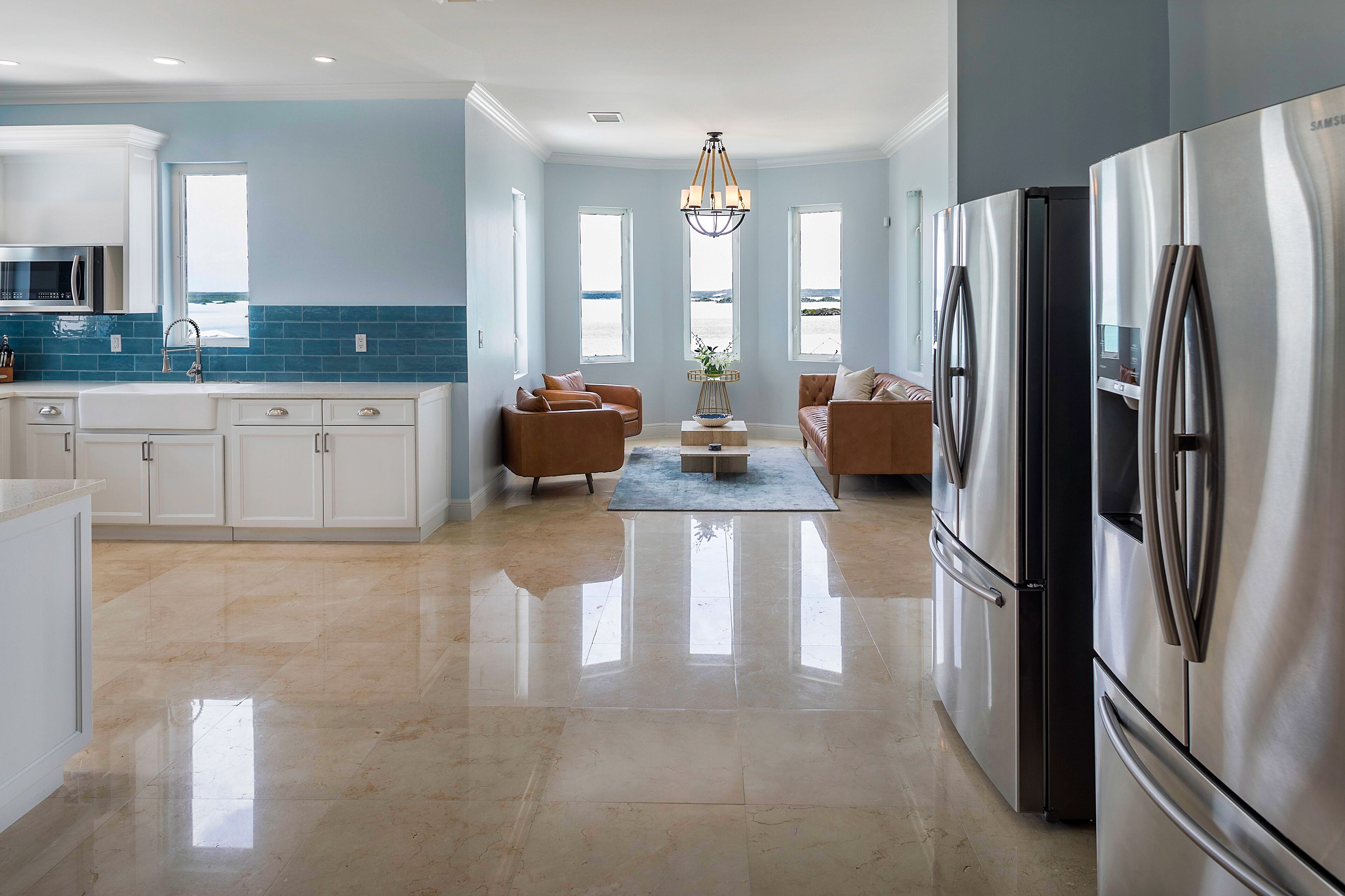 A kitchen and a sitting area with a view of the water.