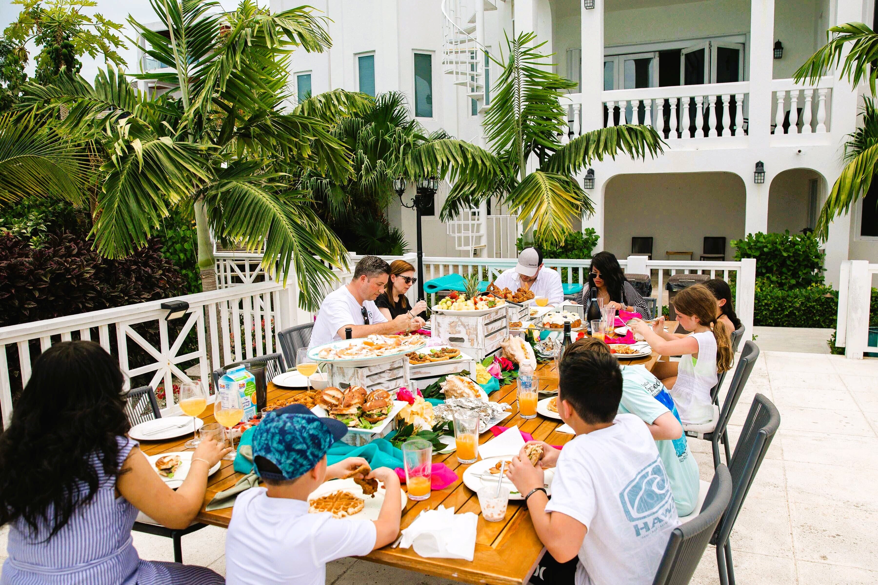 Guests at an outdoor table by the villa.