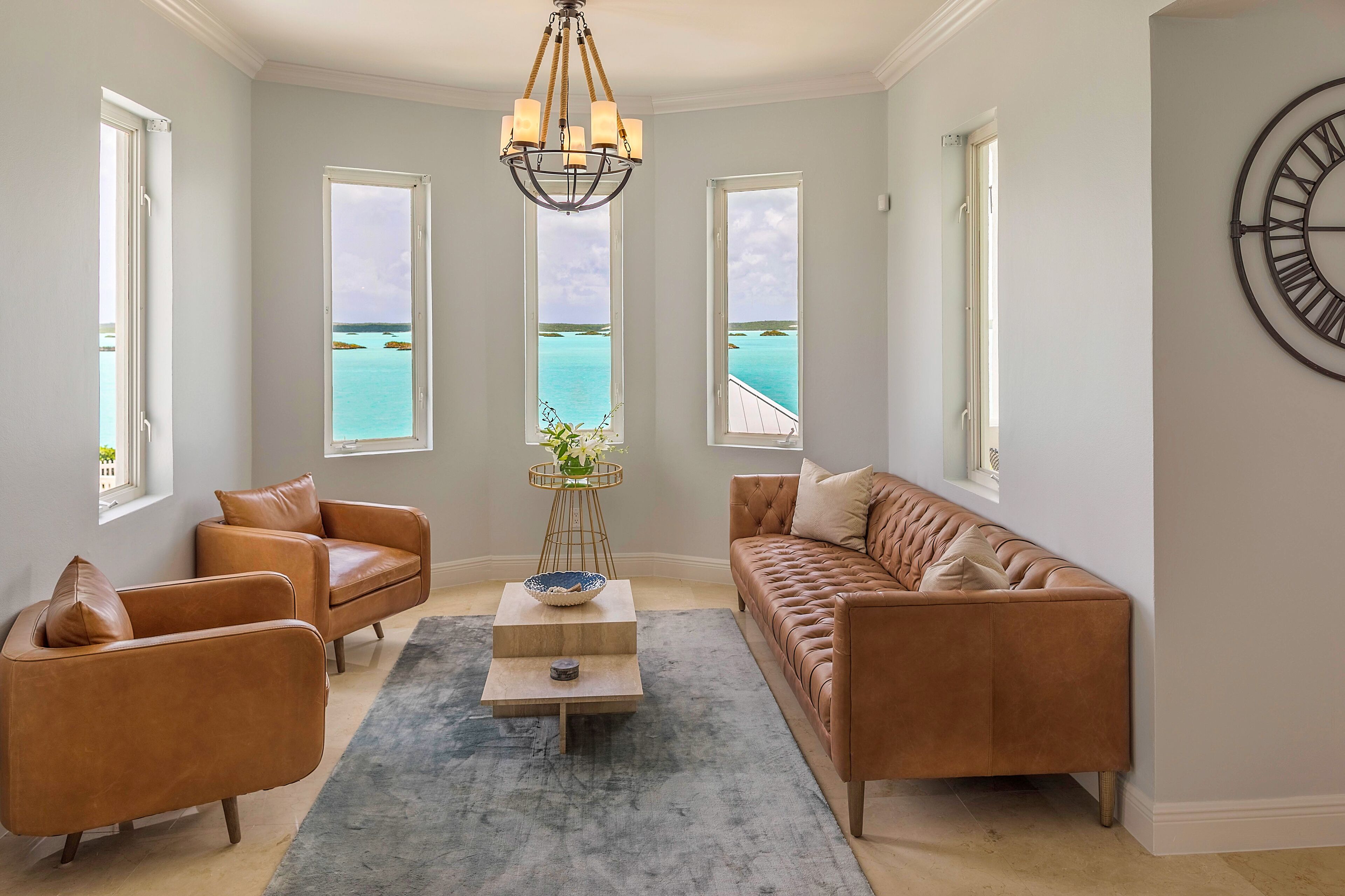 A sitting room with leather seats and a view of Chalk Sound.