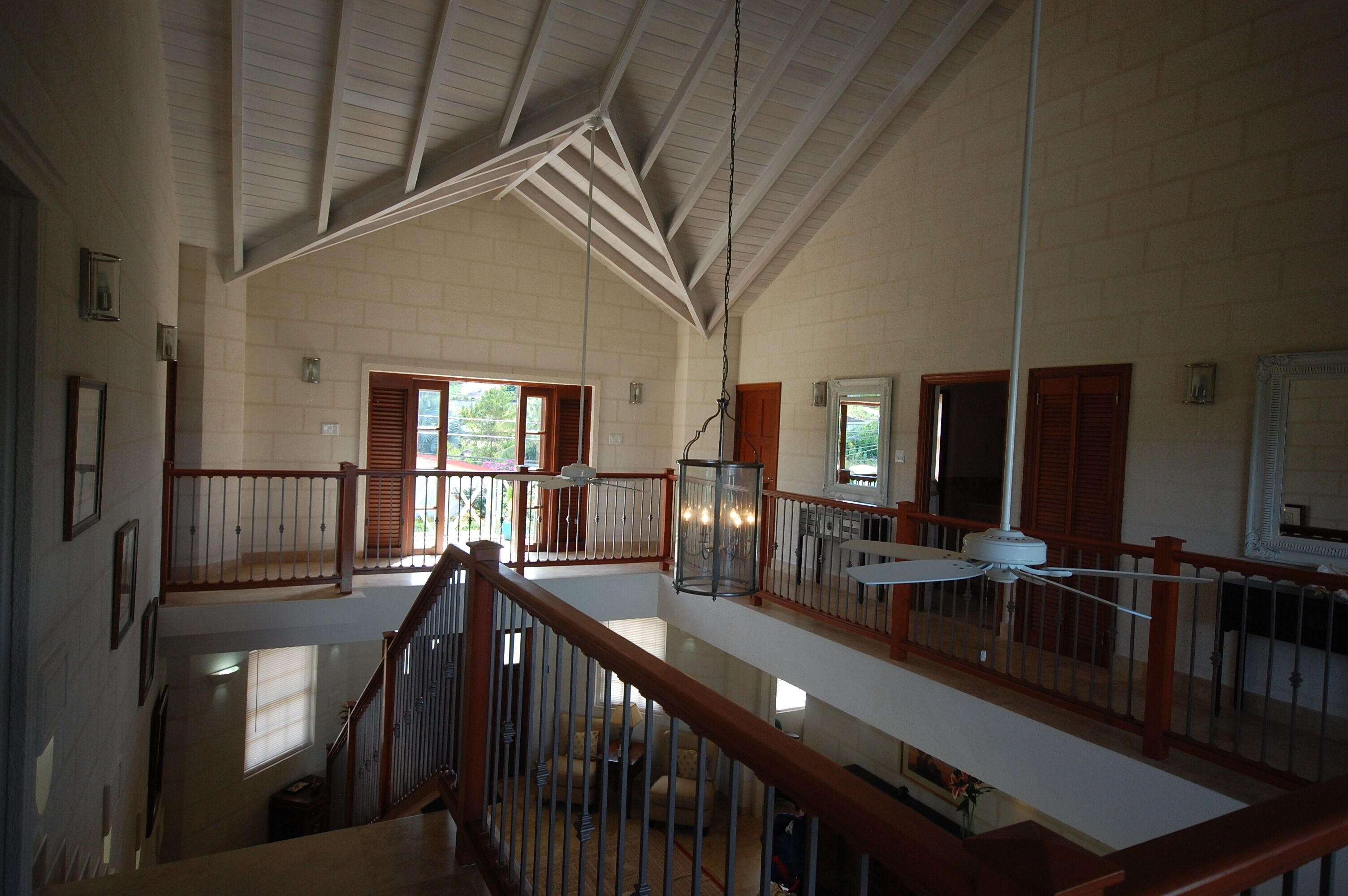 A view from the upper landing across the two-story living area, with a vaulted wood ceiling.