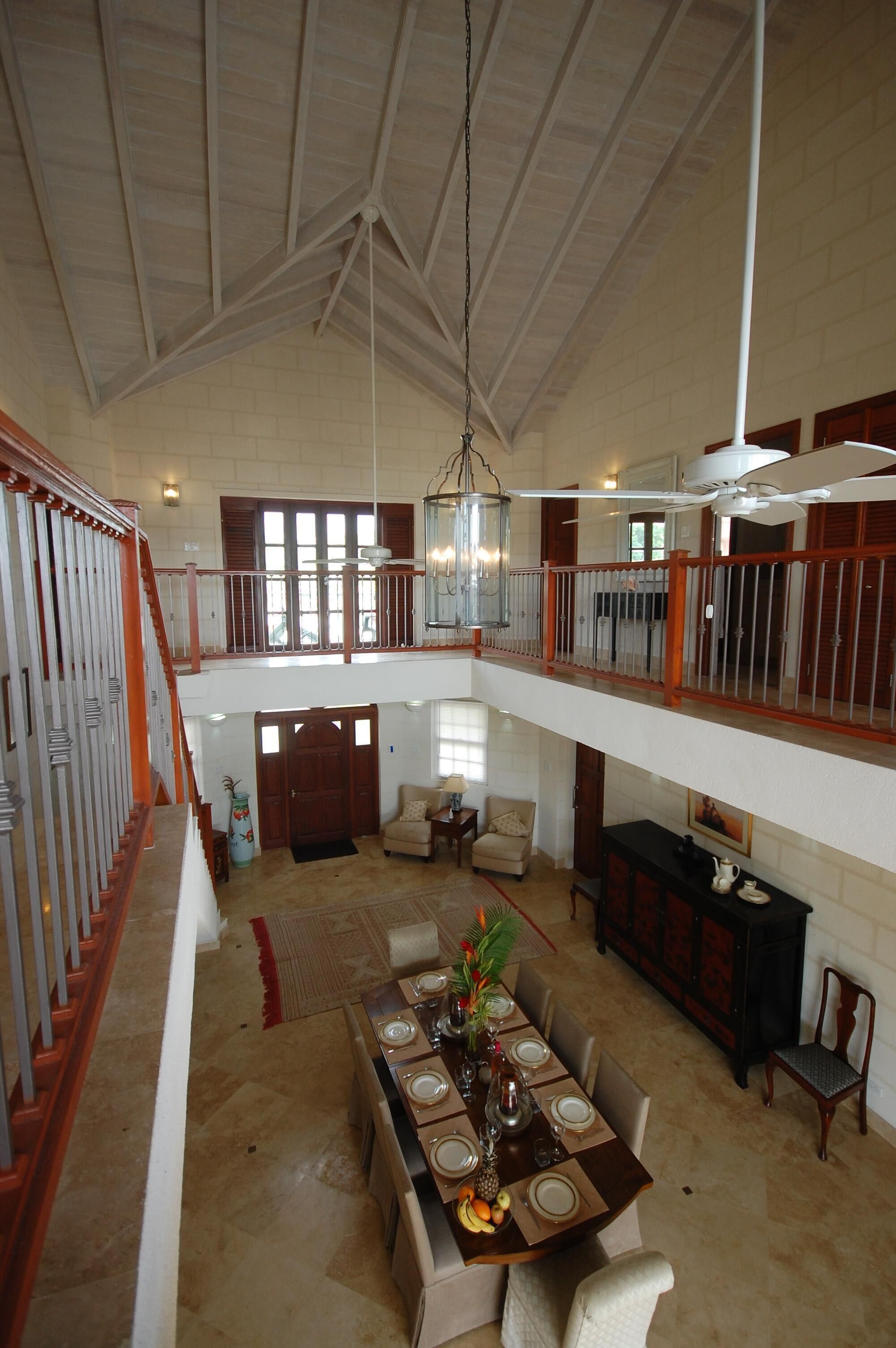 A view from the upper gallery down to the dining table in the two-story hall.