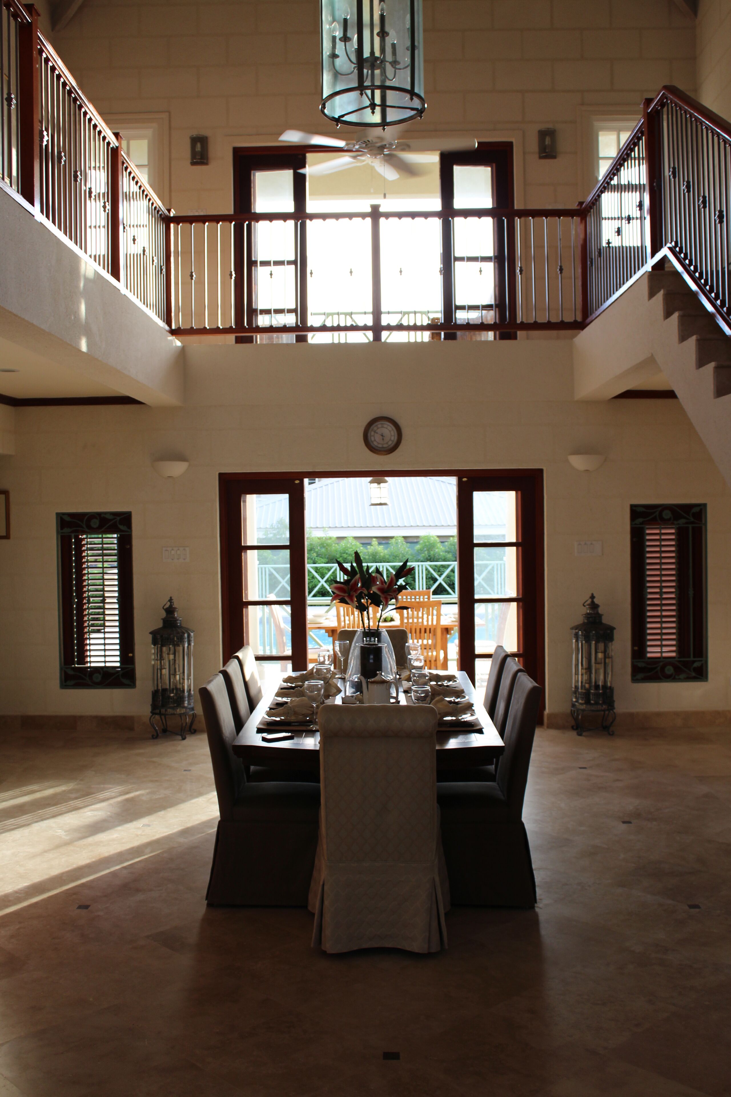 The dining table in the hall, with open doors to the veranda and the pool.
