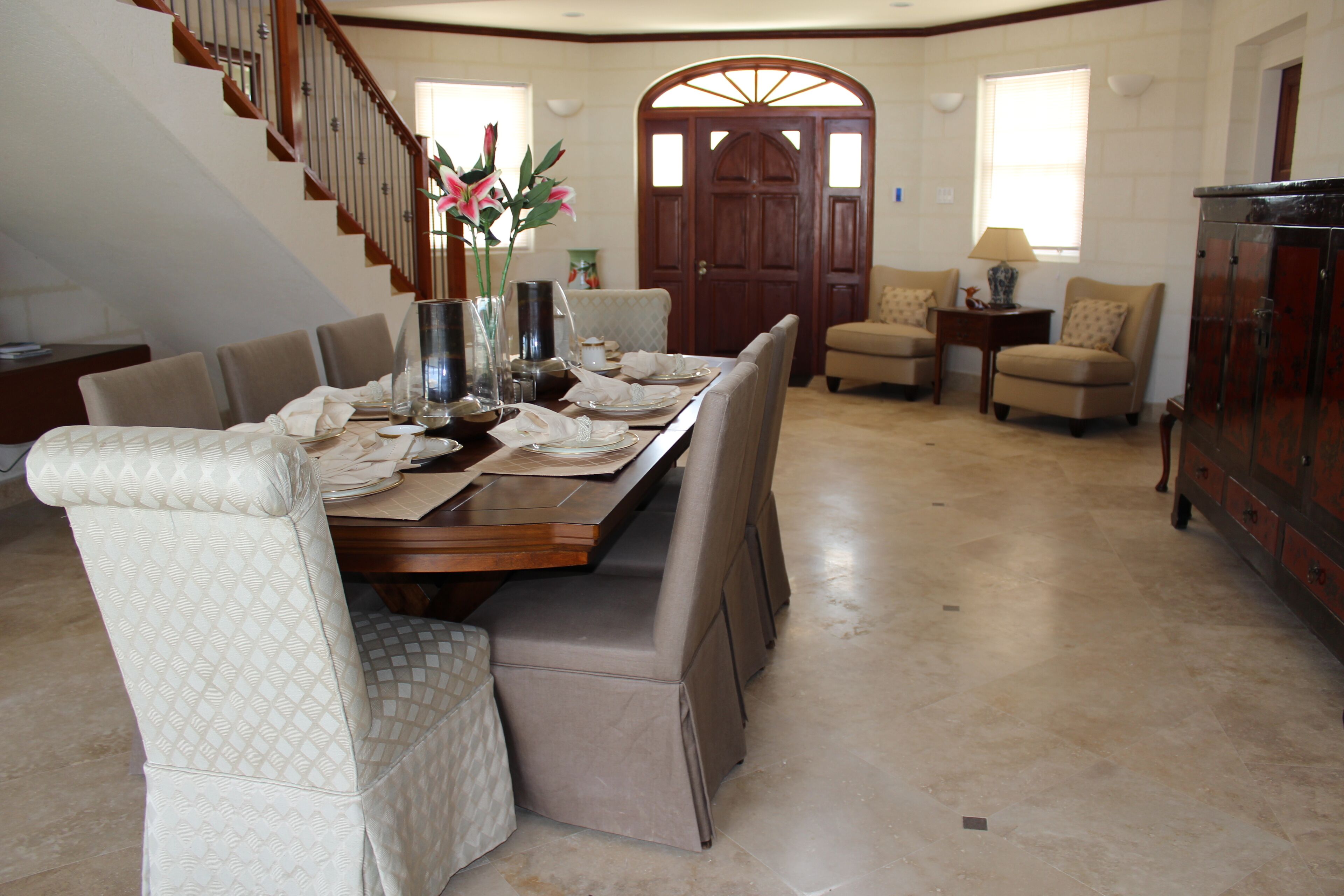 The dining area near the front door, with a table set for a meal and two armchairs.