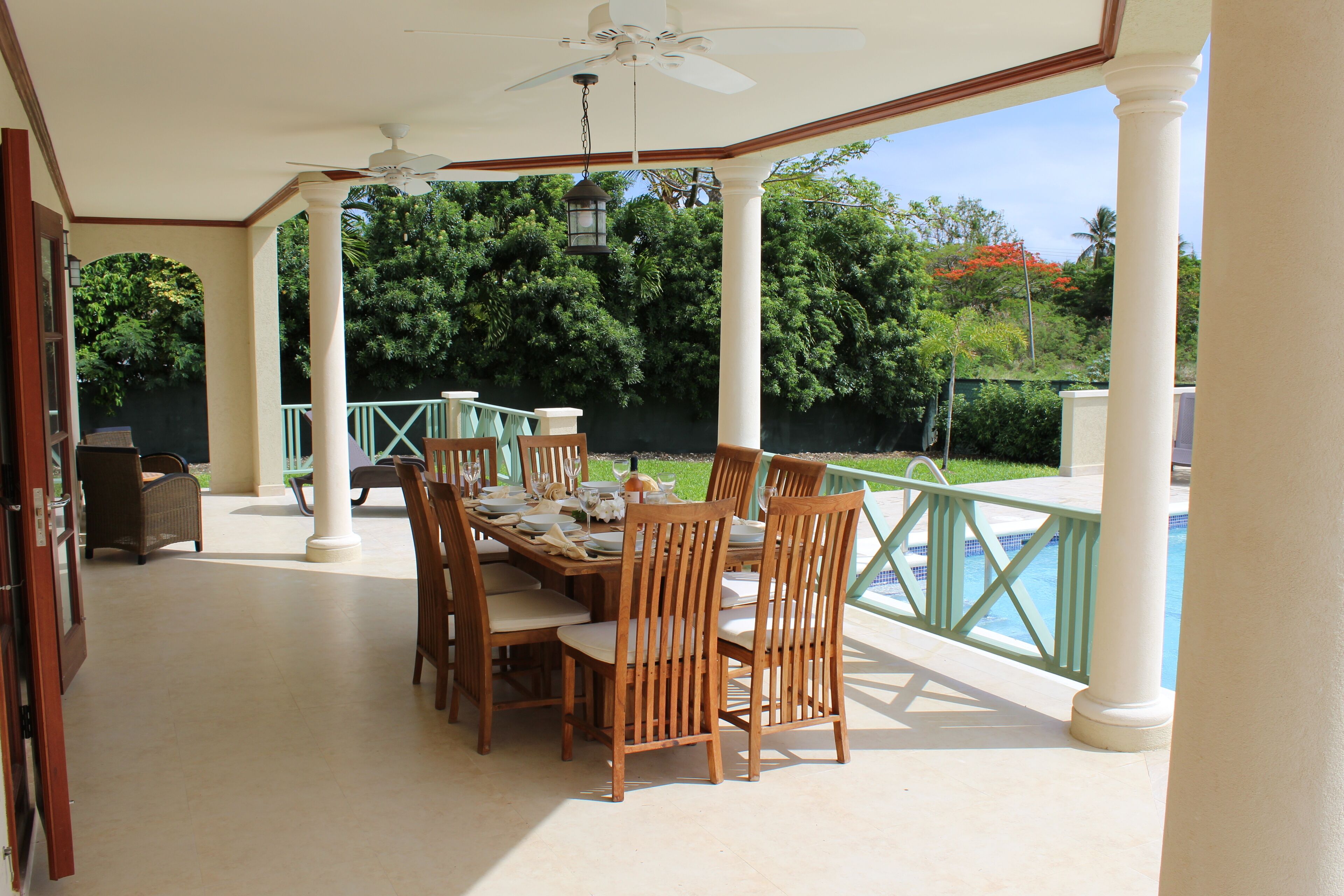 The dining table on the covered veranda next to the pool.