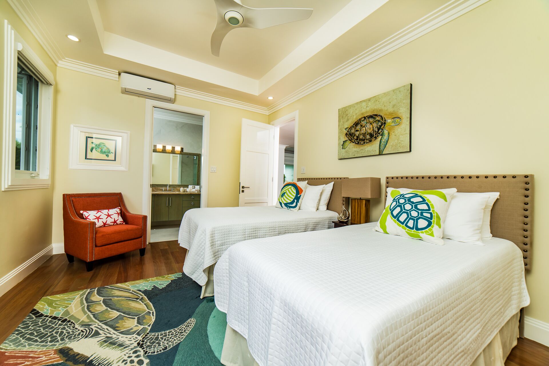 A bedroom with two beds and turtle art.
