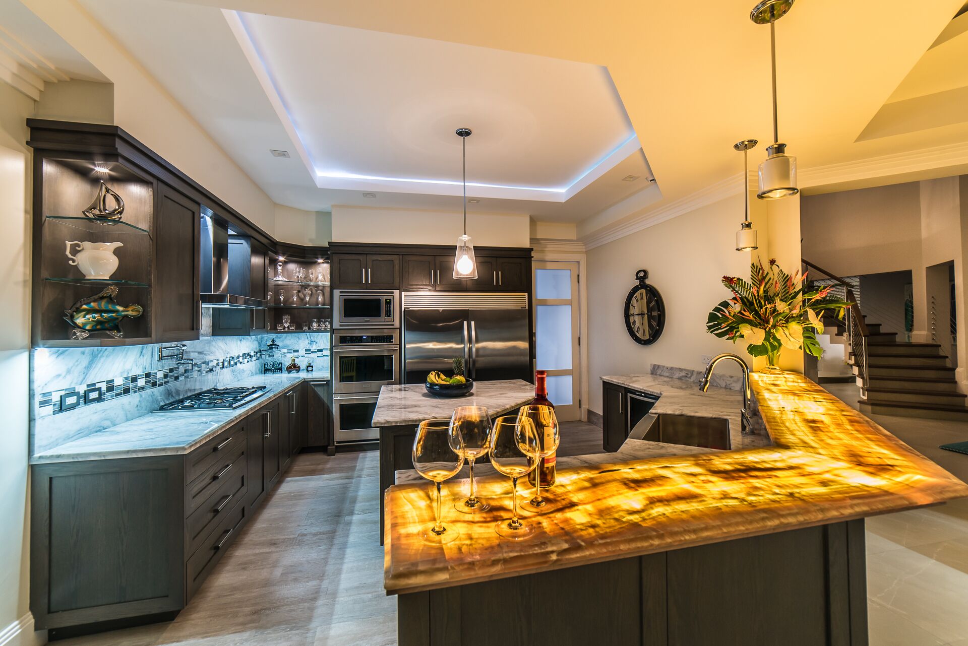 The kitchen with an island and a lit bar counter.