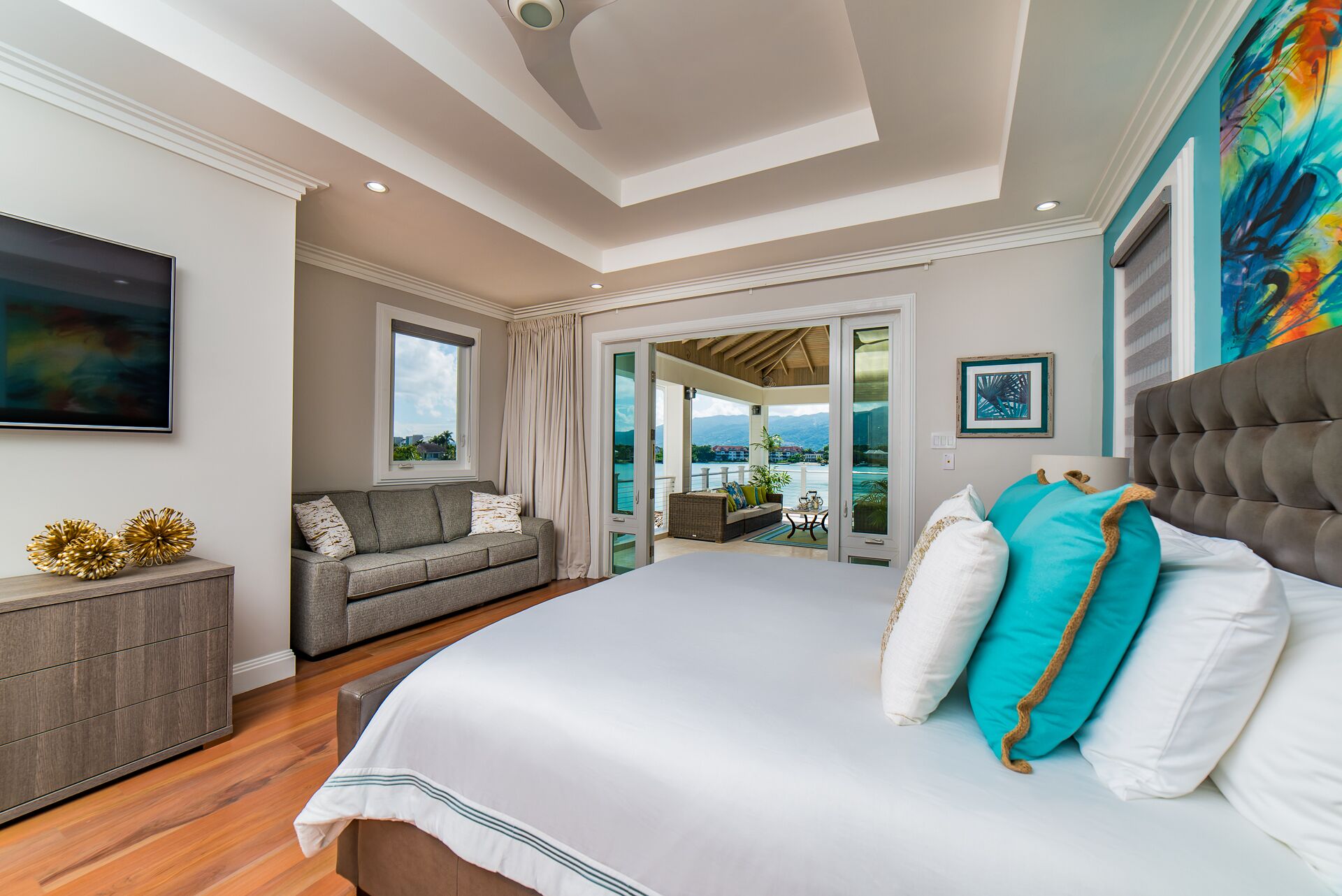 A bedroom with a king bed, a sofa, and a terrace.