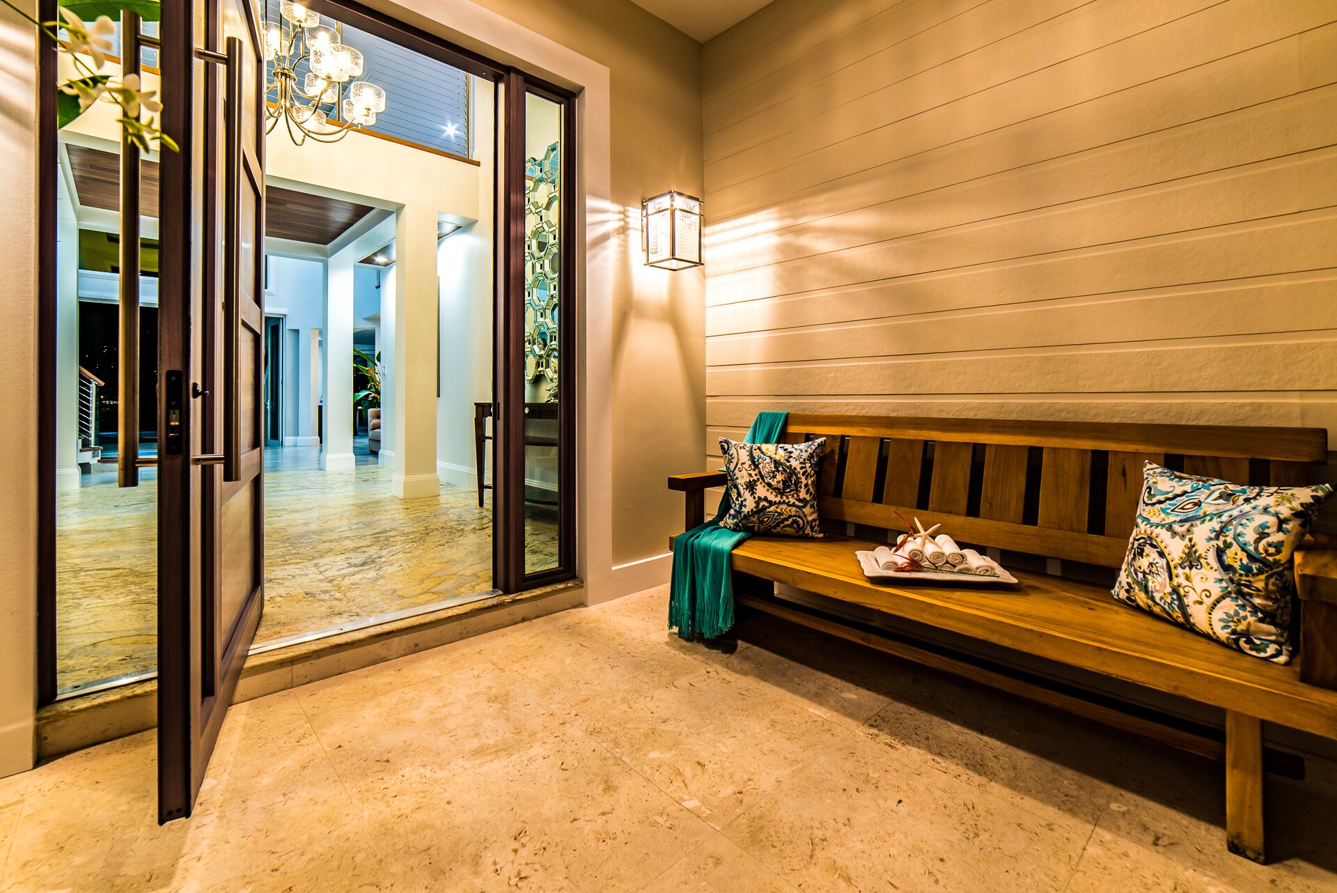The entry with a double door and a wood bench.