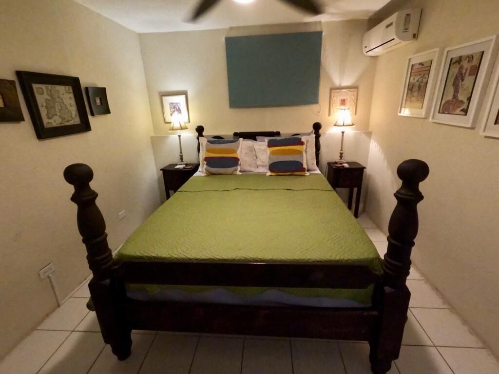 A bedroom with a four-poster bed and two lamps.