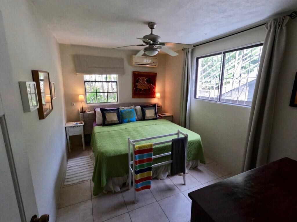 A bedroom with a double bed and an air conditioner.