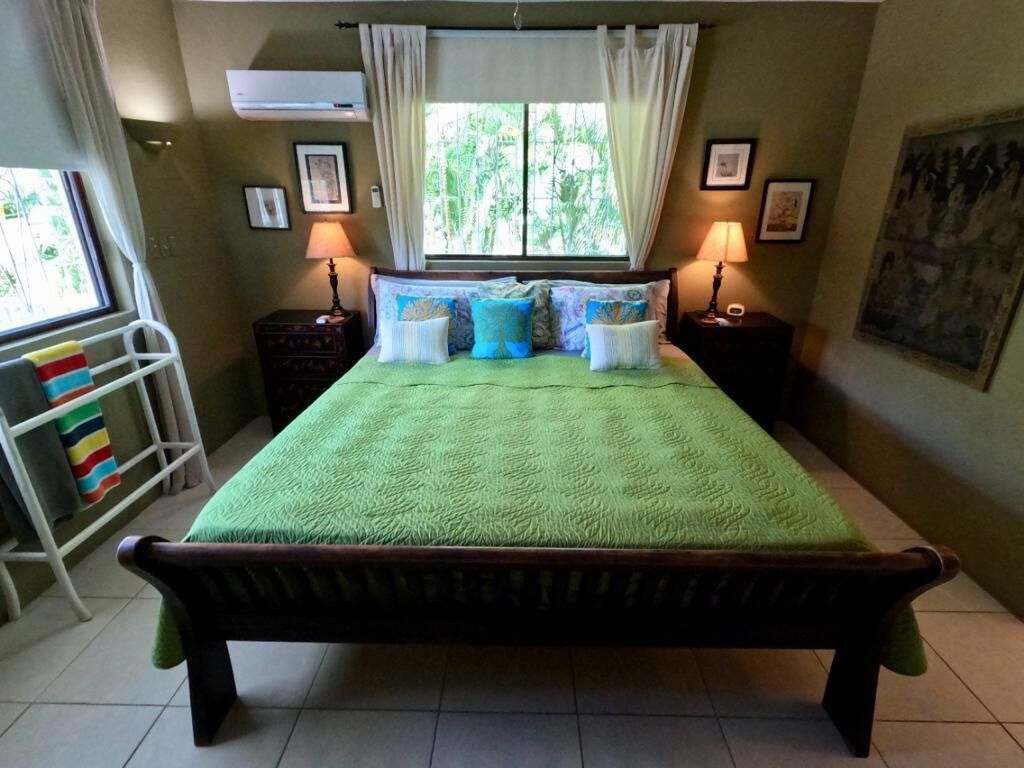 A bedroom with a wood bed, two lamps, and a window.