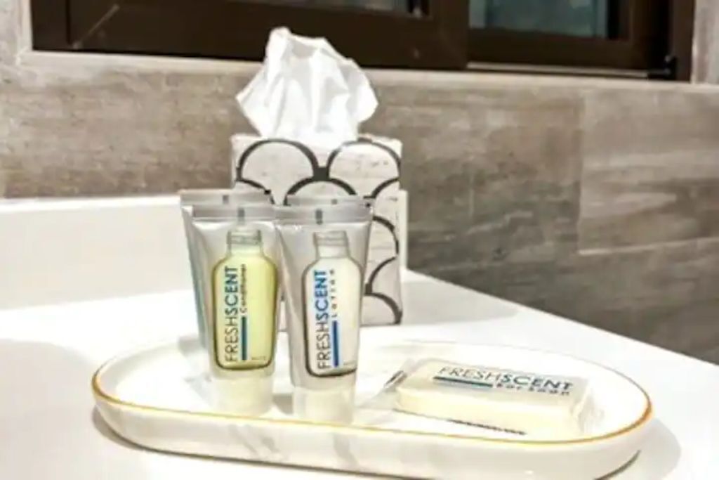 A bathroom counter with small toiletry bottles, a bar of soap, and a tissue box.