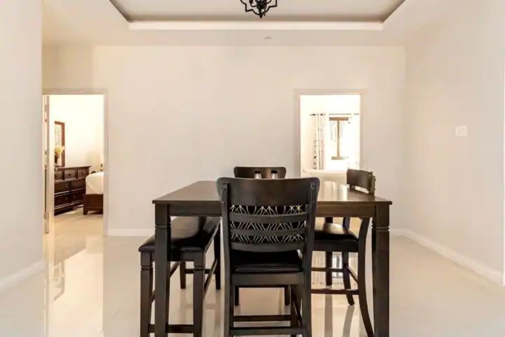 A dining area with a dark wood table and chairs.
