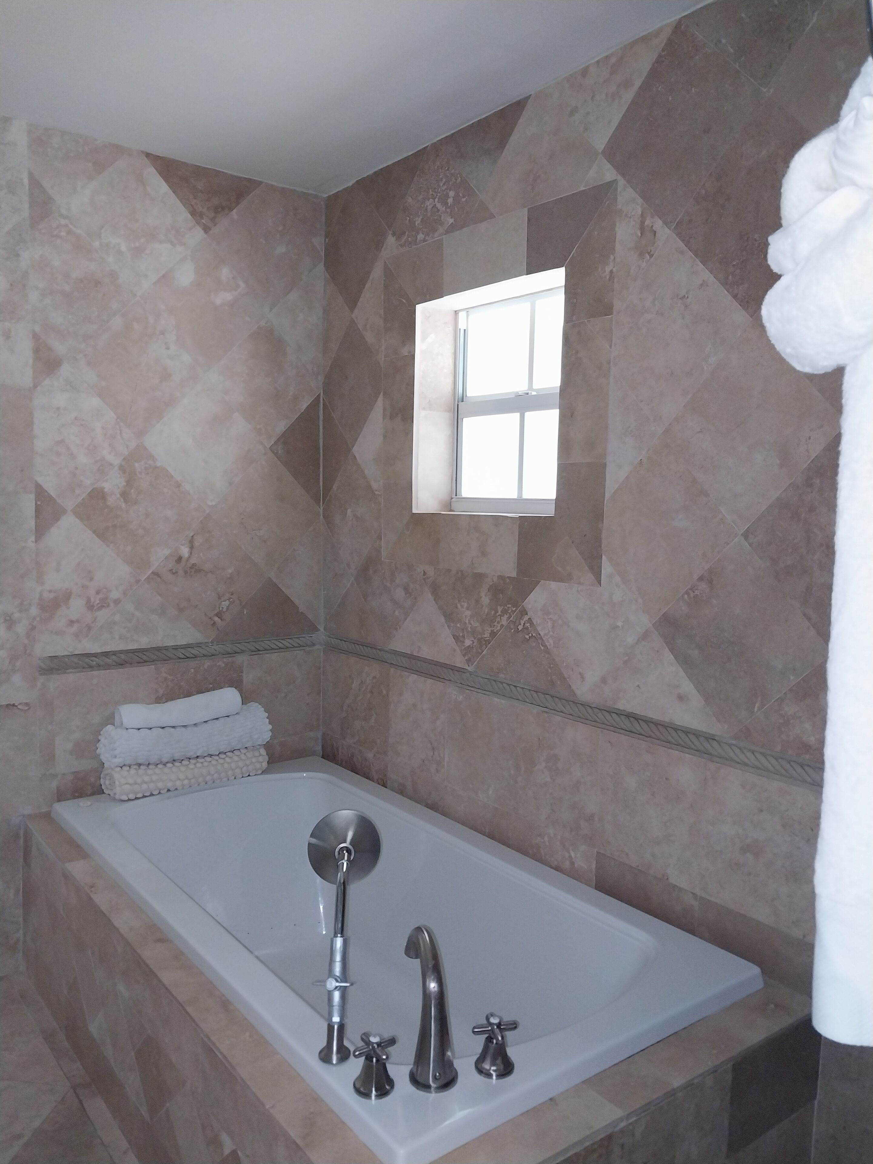 A bathtub with tile walls.