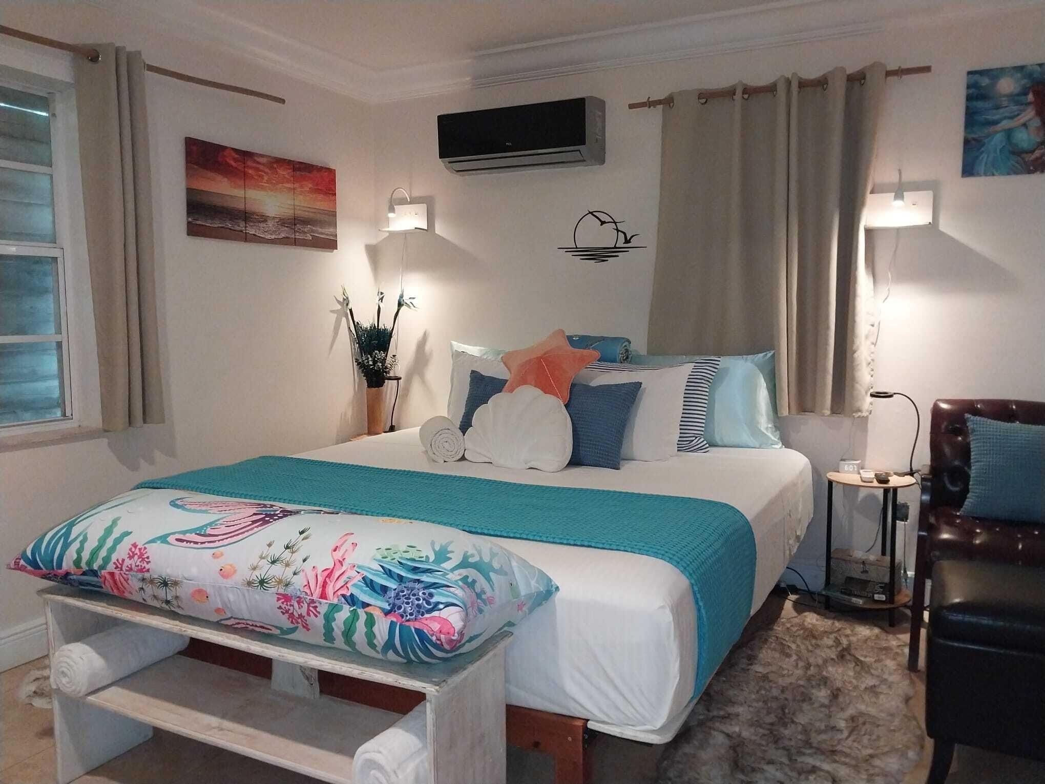 A bedroom with a king bed and a bench.