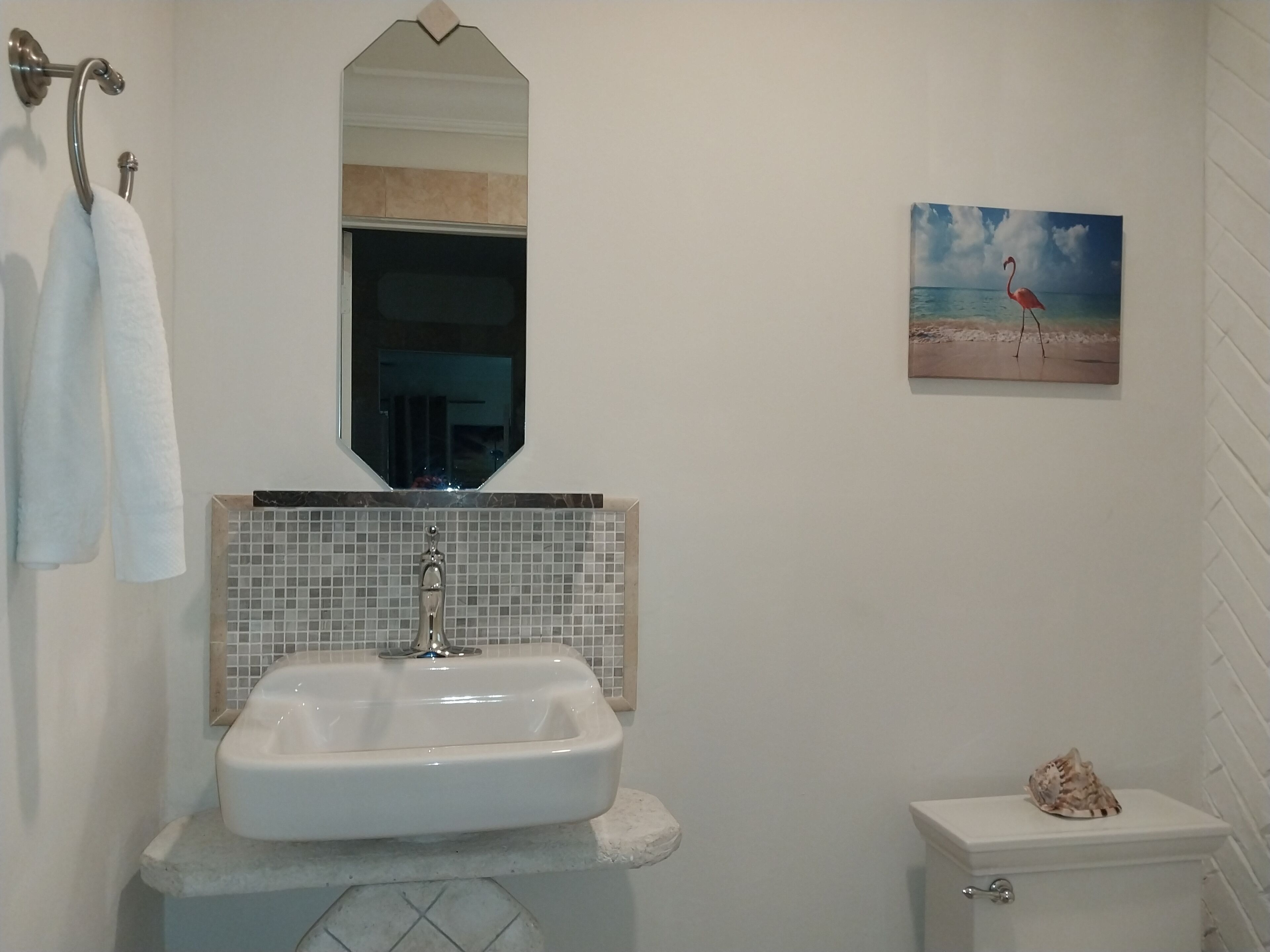 A bathroom with a sink, a mirror, and a toilet.