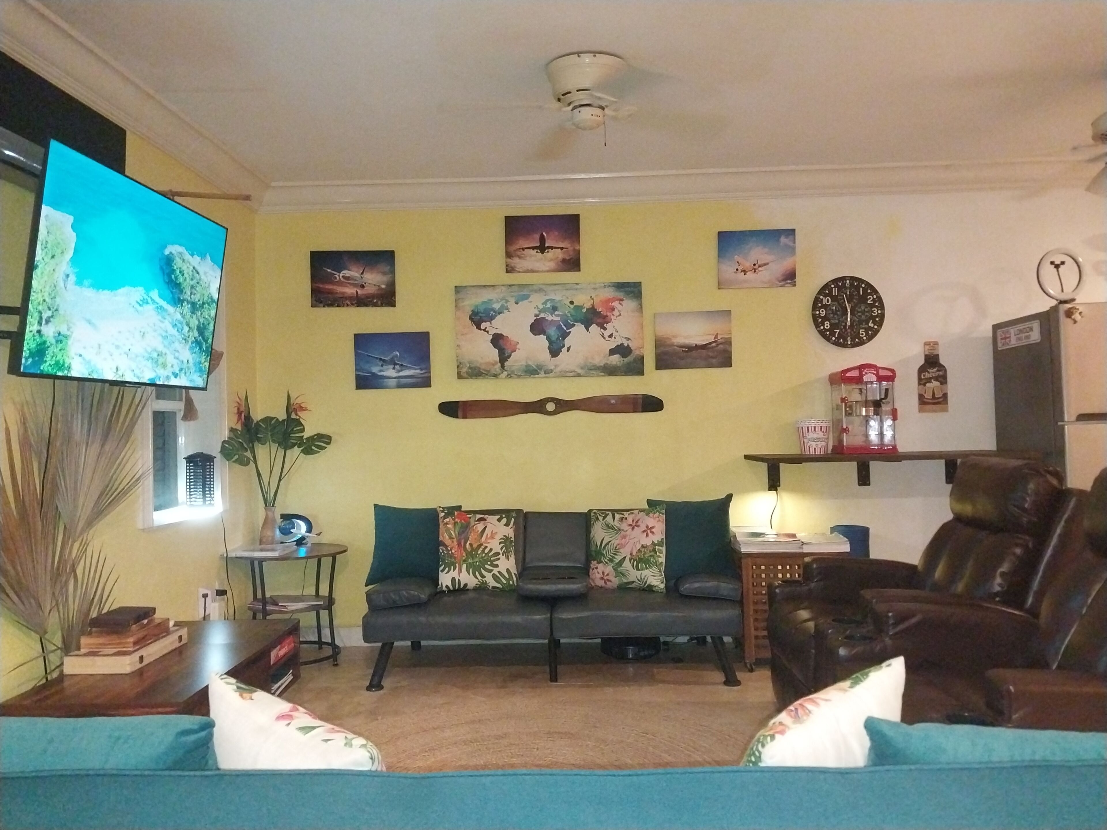 The living room with a sofa, two recliners, and a television.