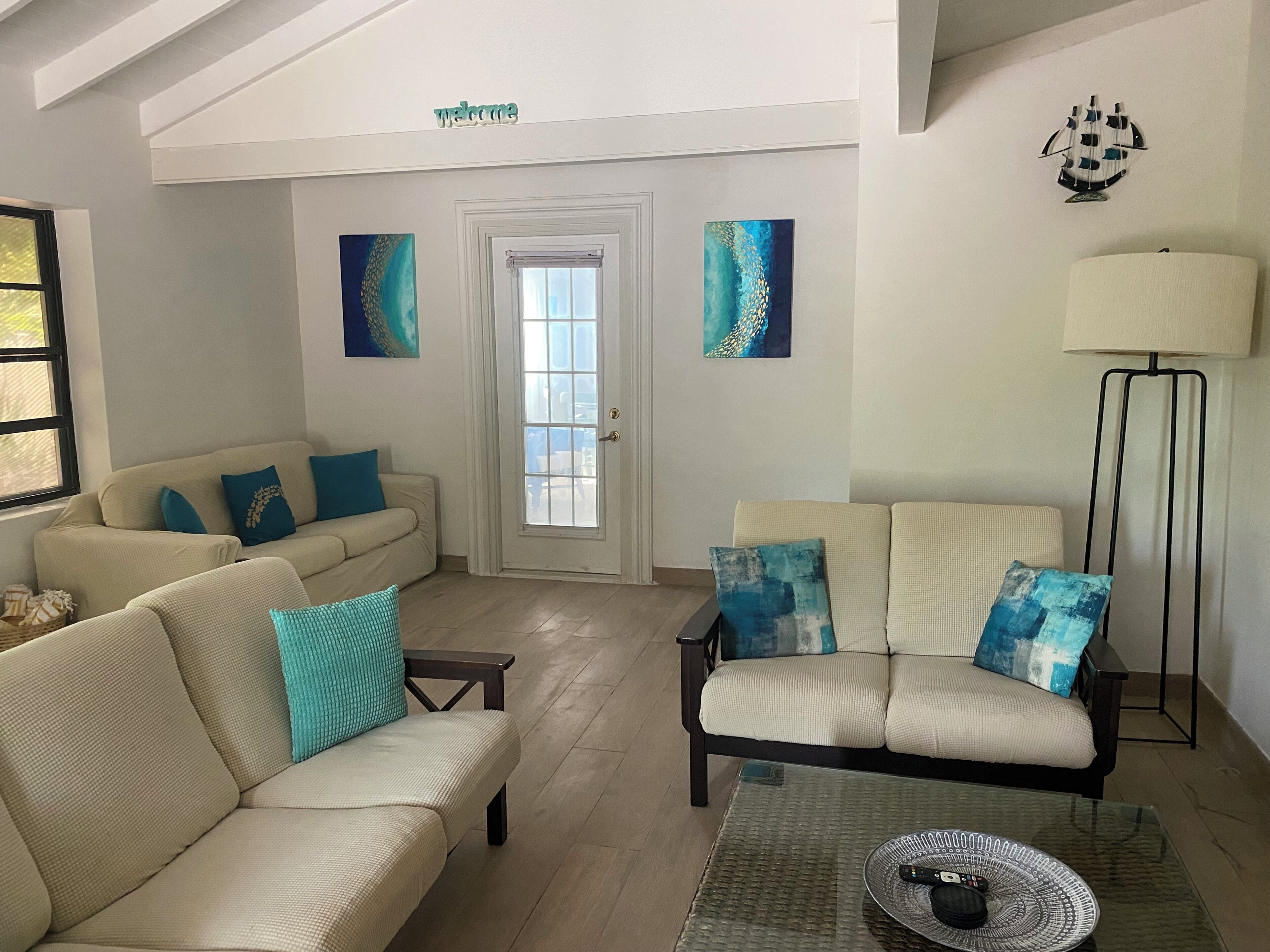 The living room with cream sofas and blue pillows.