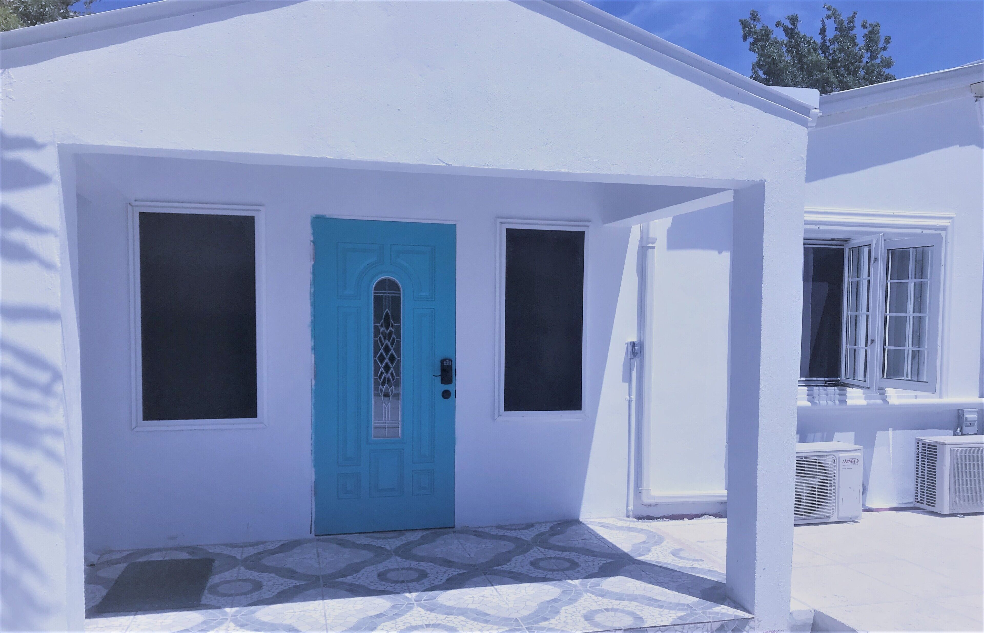 The entrance of the villa with a turquoise front door.