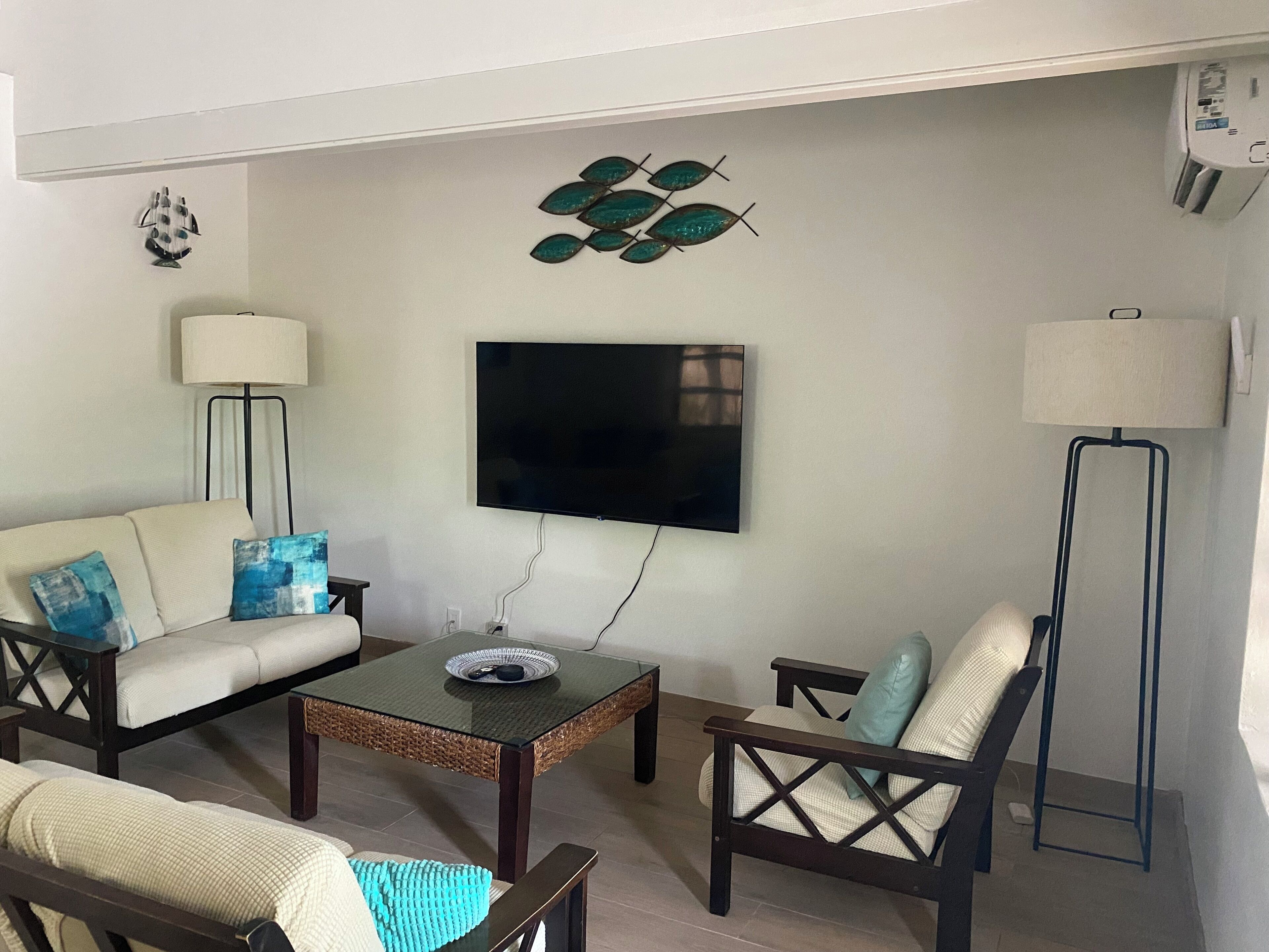 The living room with a wall television and two floor lamps.